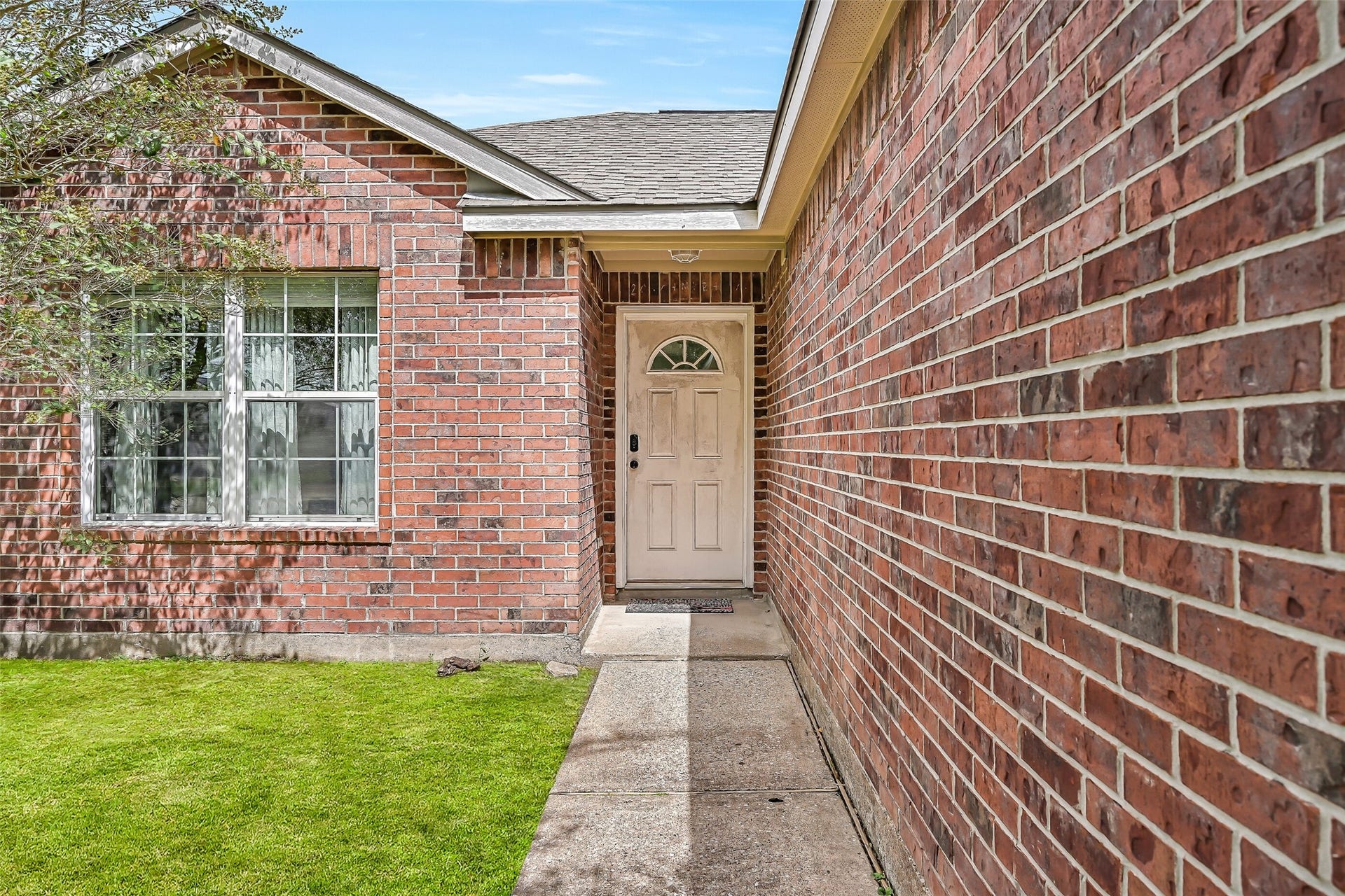 9022 Amberjack Drive, Texas City, TX 77591 A brick-lined walkway leads to the recessed front entry, creating a sheltered approach to this single-story home.
