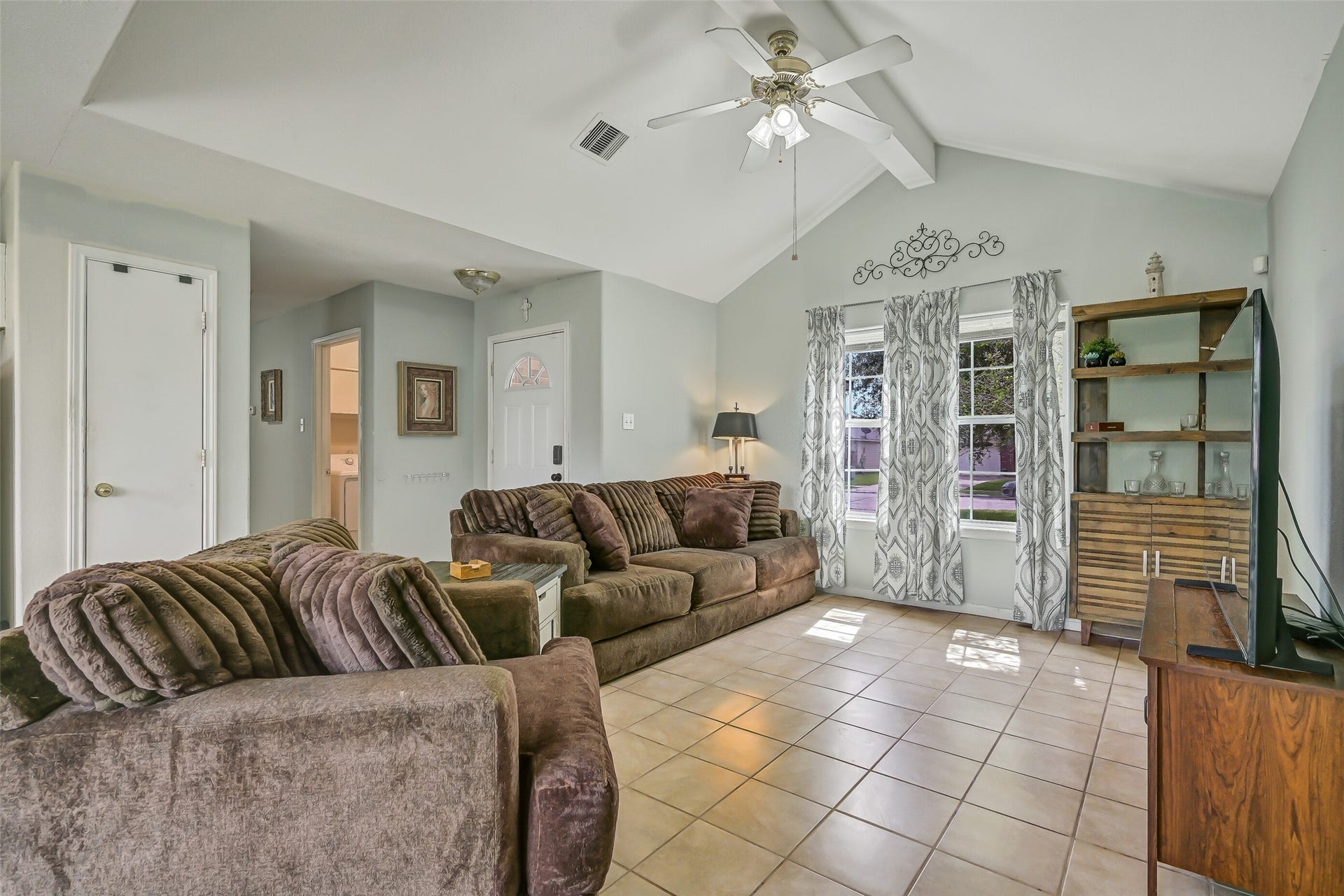 9022 Amberjack Drive, Texas City, TX 77591 The spacious family room is highlighted by a dramatic vaulted ceiling, ceiling fan, and a pair of windows that bring natural light into the heart of the home.