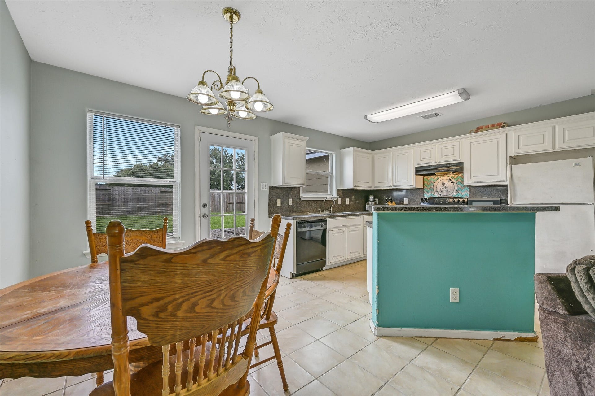 9022 Amberjack Drive, Texas City, TX 77591 The open kitchen overlooks the dining and family rooms and features a breakfast bar peninsula, abundant cabinetry, generous counter space, and convenient backyard access nearby.