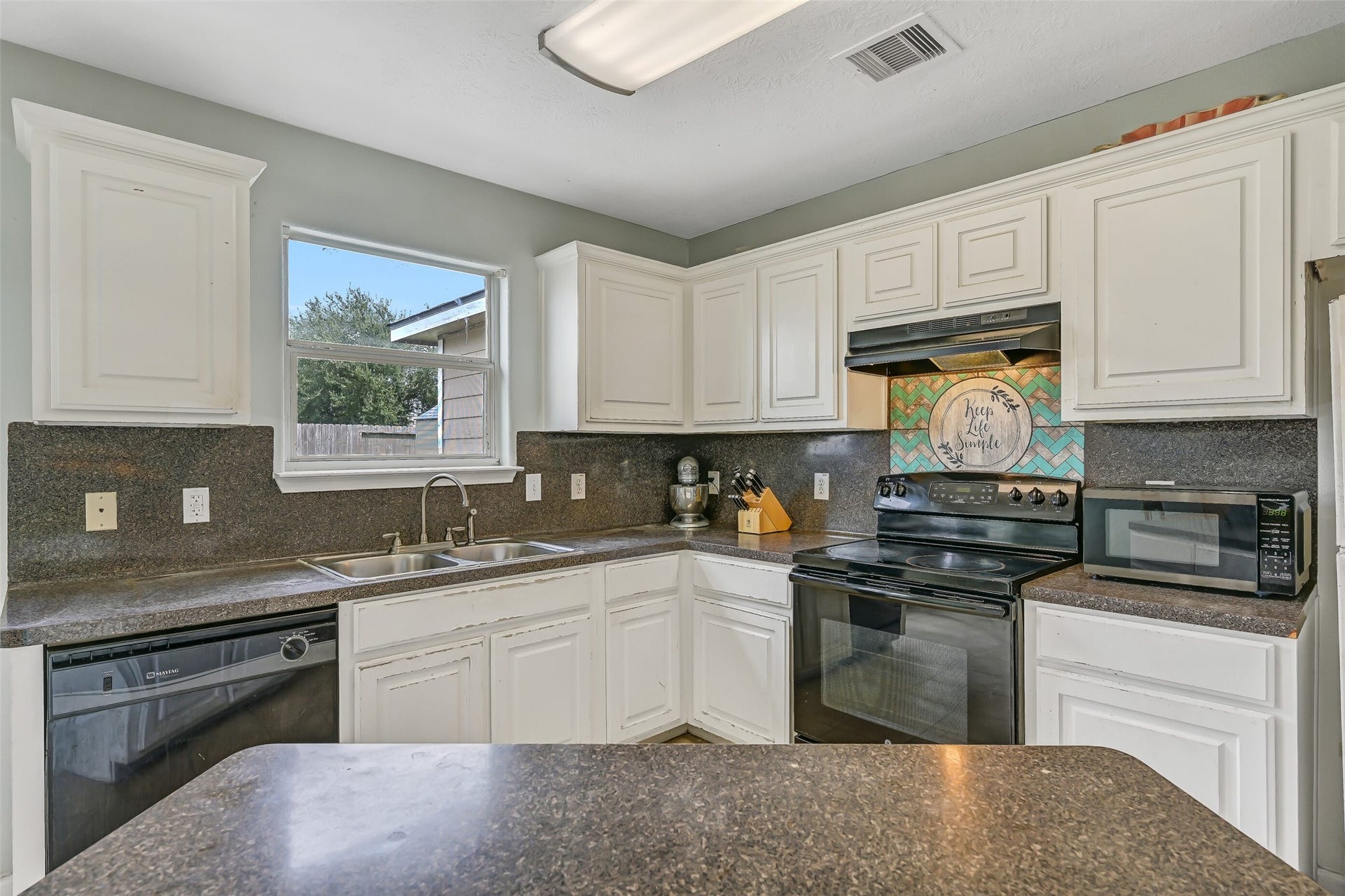 9022 Amberjack Drive, Texas City, TX 77591 Plenty of cabinetry and counter space provide practical kitchen storage and prep room, while a window above the double-basin sink brings in natural light.