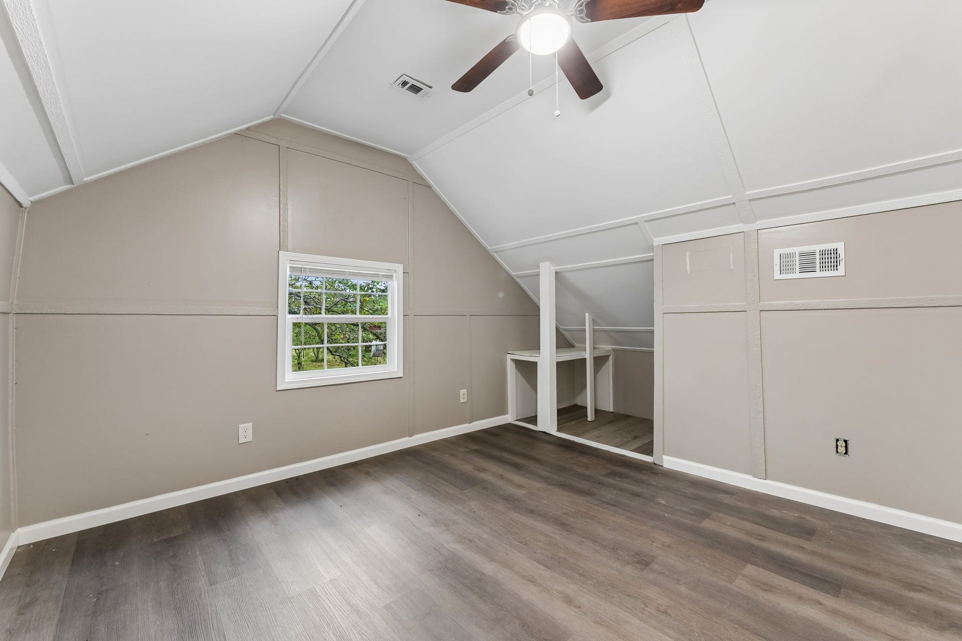 10534 Hufsmith Road, Tomball, TX 77375 Upper-level bedroom showcases the original room, natural light, vaulted ceiling, and generous floor space behind the virtually staged cowboy bunkroom.