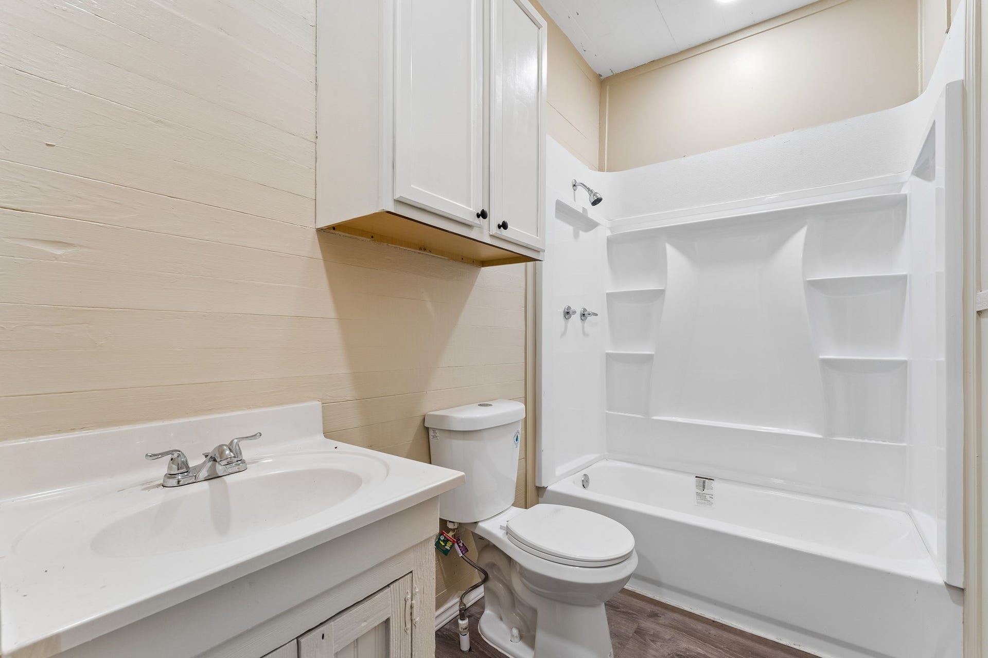 10534 Hufsmith Road, Tomball, TX 77375 Bright downstairs bath with white tub/shower surround, built-in shelving, and practical vanity space.