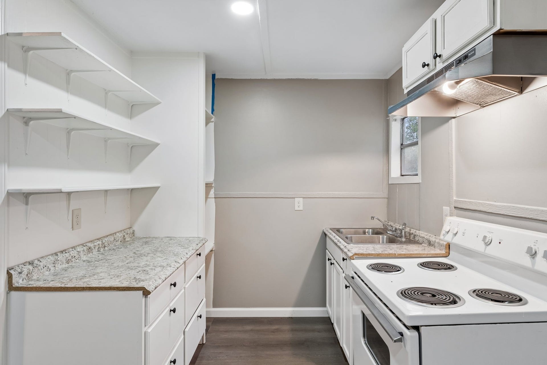10534 Hufsmith Road, Tomball, TX 77375 Updated kitchen featuring white cabinetry, granite-style countertops, abundant storage, full-size electric range, double-basin sink, and a functional layoutwell suited for everyday living, weekend stays, or a future Airbnb/short-term rental experience.