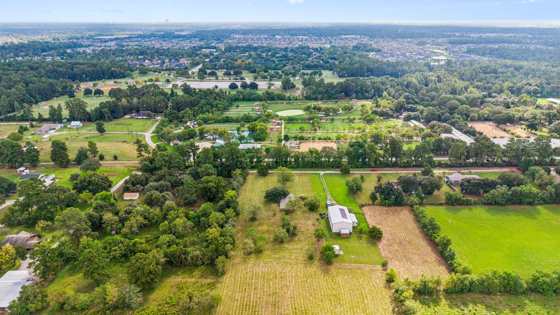 10534 Hufsmith Road, Tomball, TX 77375 Aerial overview showcases the property's generous acreage and private rural setting, offering room for animals, recreation, a pond, gardens, or future plans.