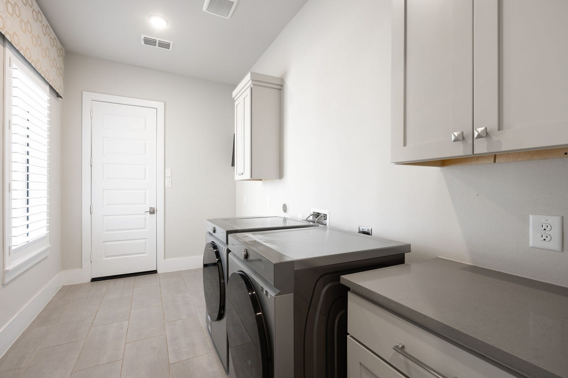 27927 Indigo Ridge Drive, Fulshear, TX 77441 Convenient laundry room featuring built-in cabinetry, counter space, and room for everyday household needs.