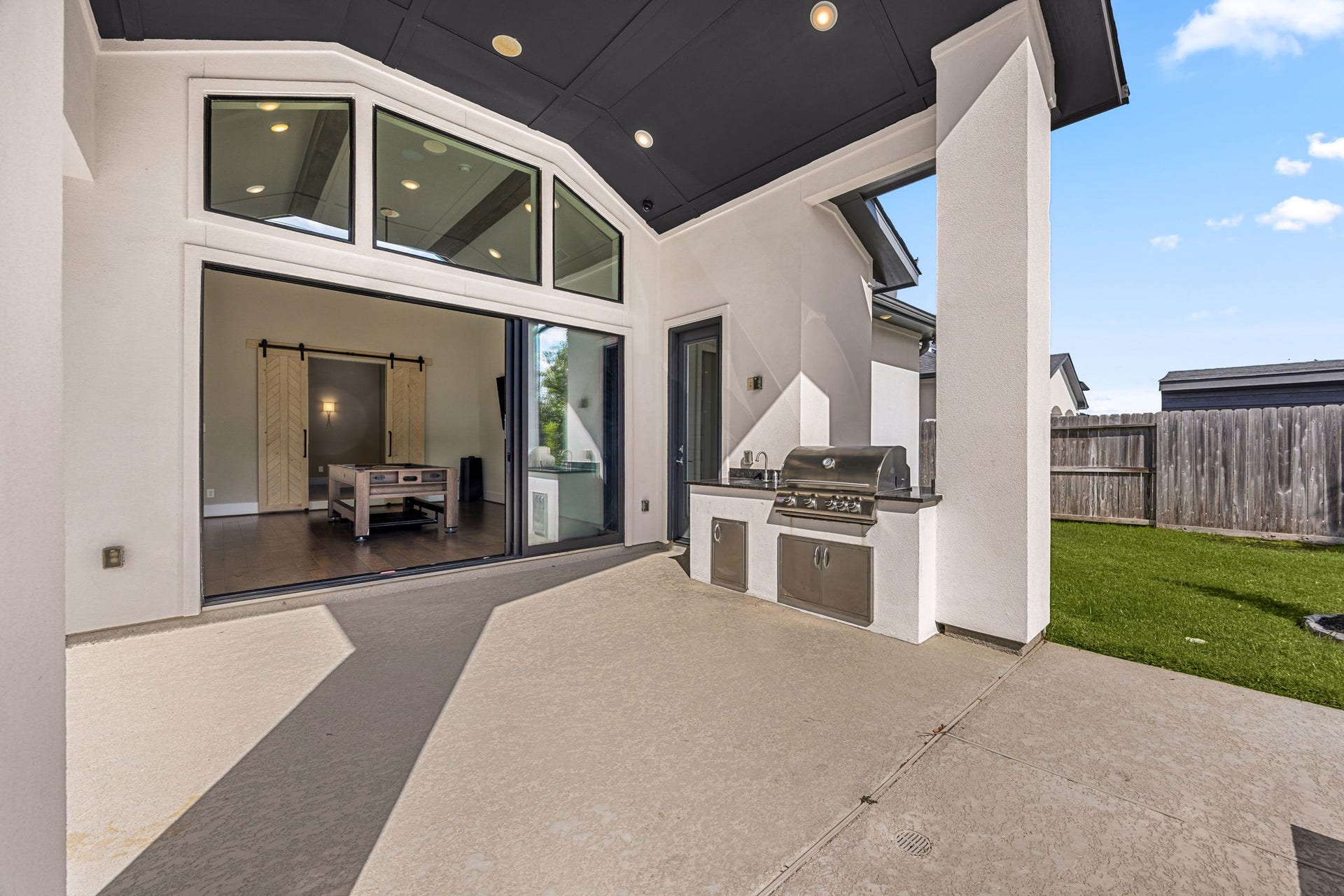 27927 Indigo Ridge Drive, Fulshear, TX 77441 Additional covered area featuring beautiful architectural details and a built in outdoor kitchen with grill and sink, perfect for entertaining.