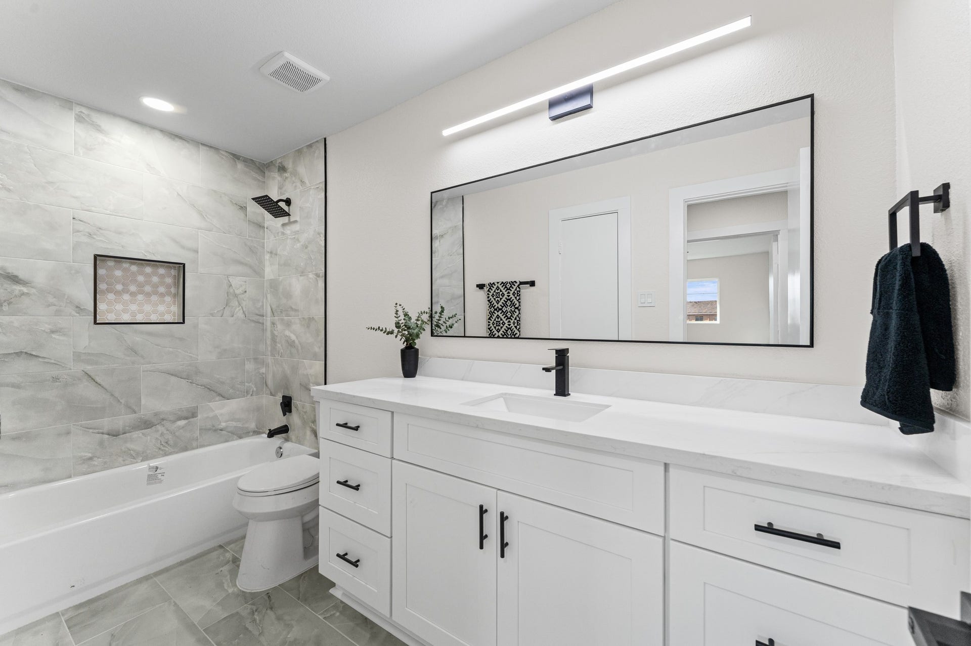 14387 Misty Meadow Lane, Houston, TX 77079 The secondary bathroom has been updated with a new tiled shower and brand-new tub combo, new quartz countertops, a new toilet, and new cabinets.