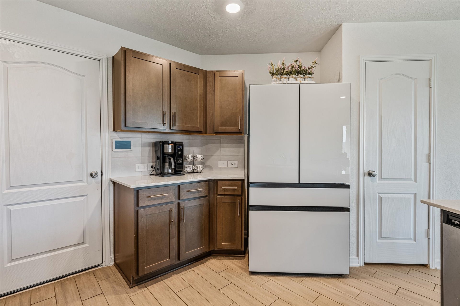 2873 Shimmer Edge Drive, Katy, TX 77493 Additional kitchen view highlighting the dedicated refrigerator space, adjacent pantry, and a cozy coffee station nook. Upper and lower cabinetry provide excellent storage, while the layout maximizes efficiency for daily routines.