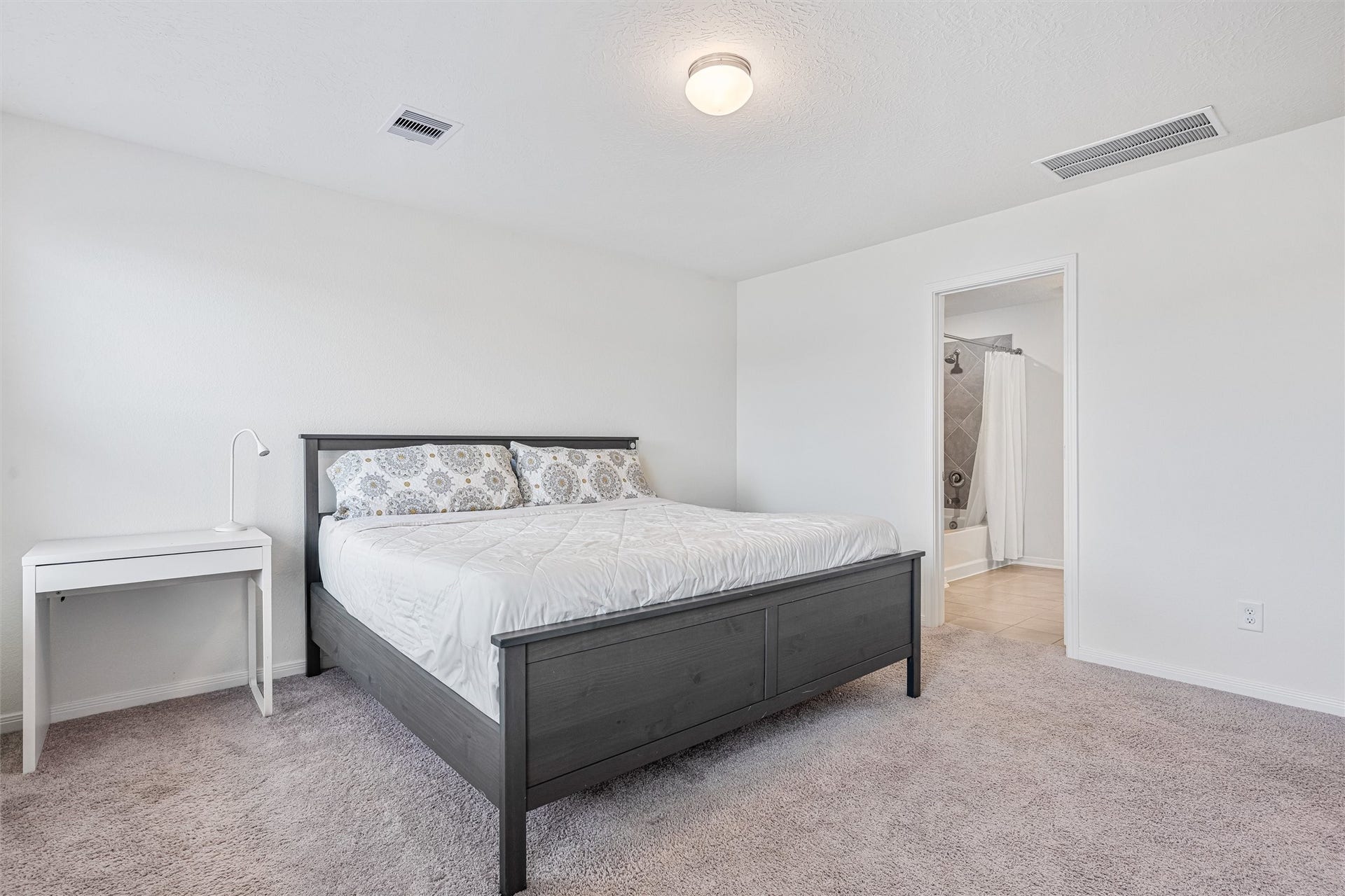 2873 Shimmer Edge Drive, Katy, TX 77493 This angle highlights the seamless connection between the primary bedroom and the ensuite bathroom. The rooms expansive layout and neutral finishes create a calming environment, perfect for unwinding at the end of the day.