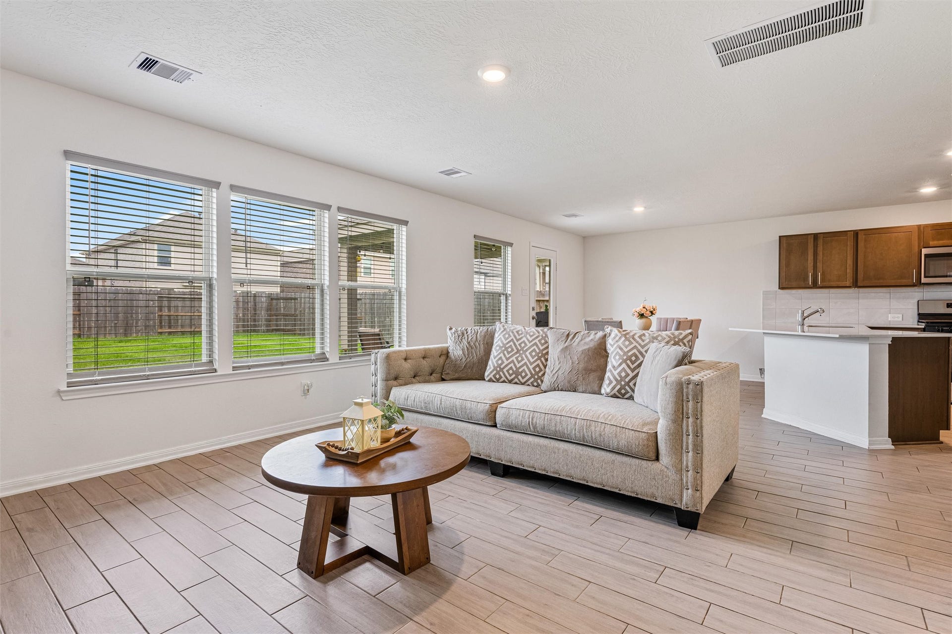 2873 Shimmer Edge Drive, Katy, TX 77493 Alternate view of the family room showcasing its seamless connection to the kitchen and dining area. The layout emphasizes the homes open-concept design. Large windows continue to bring in abundant natural light, while the positioning of the space allows for easy flow between living, dining, and kitchen areas.