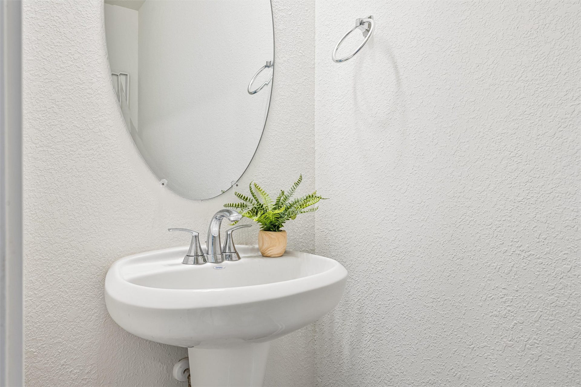 2873 Shimmer Edge Drive, Katy, TX 77493 Charming half bath featuring a classic pedestal sink, sleek chrome fixtures, and an oval mirror.