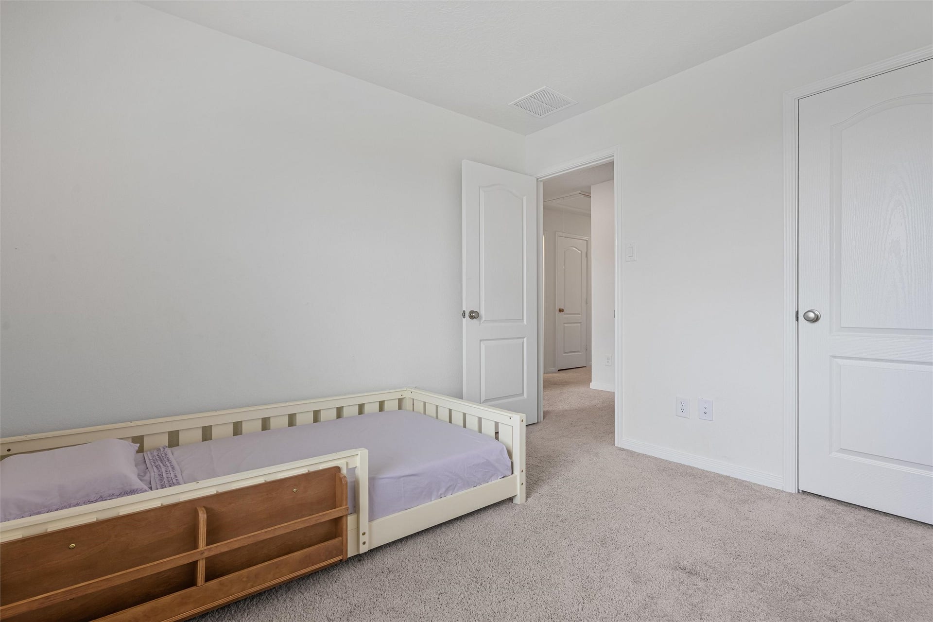2873 Shimmer Edge Drive, Katy, TX 77493 Alternate angle of the secondary bedroom showcasing its generous proportions and functional layout. This view highlights the easy access to the hallway and closet, along with clean, neutral finishes that create a move-in ready and versatile space.