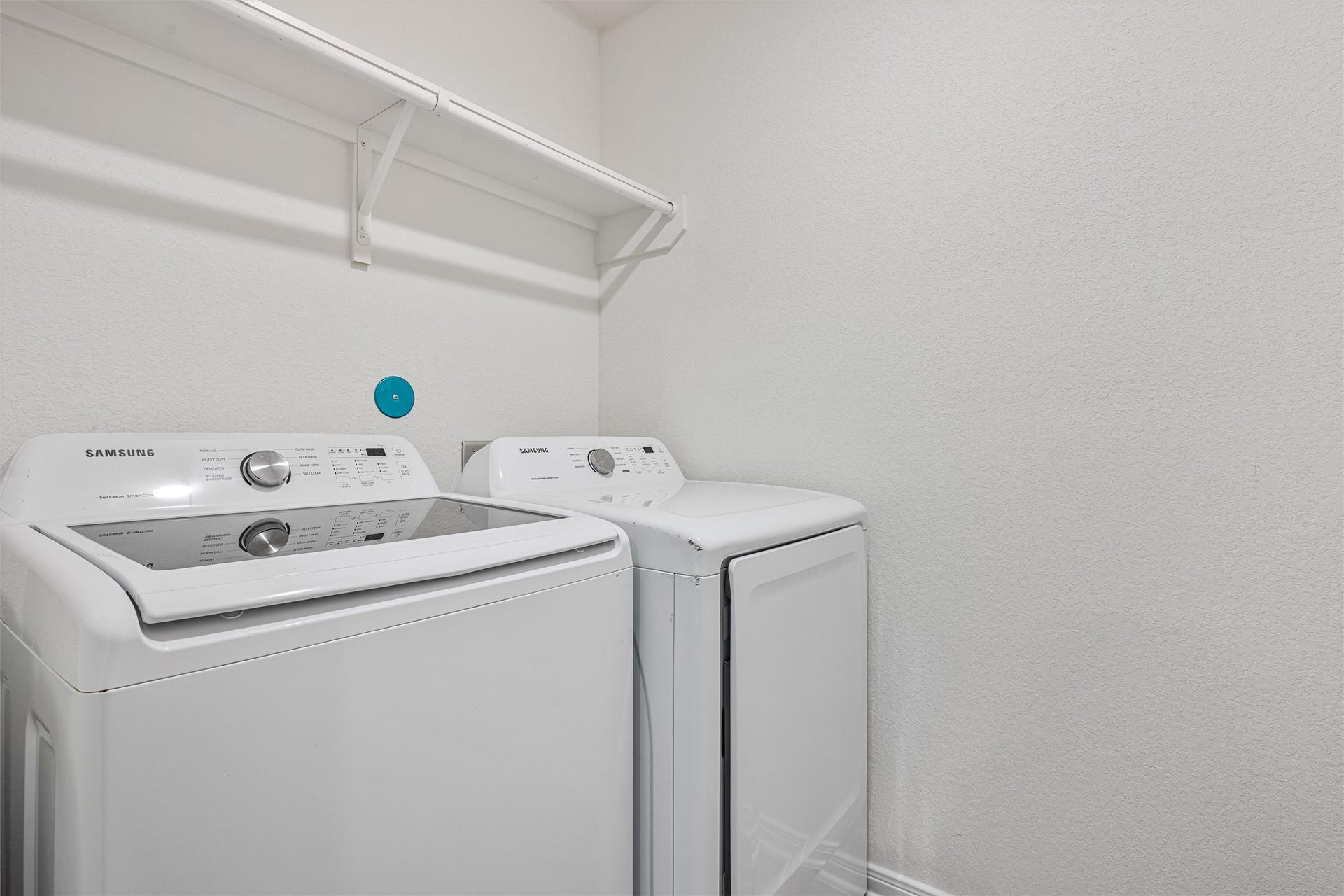 2873 Shimmer Edge Drive, Katy, TX 77493 Dedicated laundry room offering a functional and efficient space for everyday chores. A built-in hanging rod and upper shelf provide added storage and organization, making this utility area both practical and well-designed.