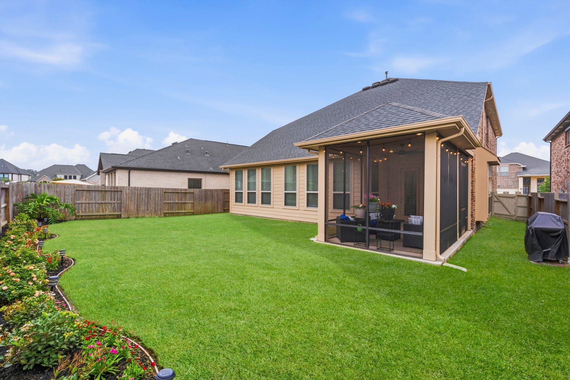 17209 Olive Blossom Court, Conroe, TX 77385 Back of the home showcases the screened-in porch, fenced yard, and nicely landscaped backyard with space for outdoor enjoyment.