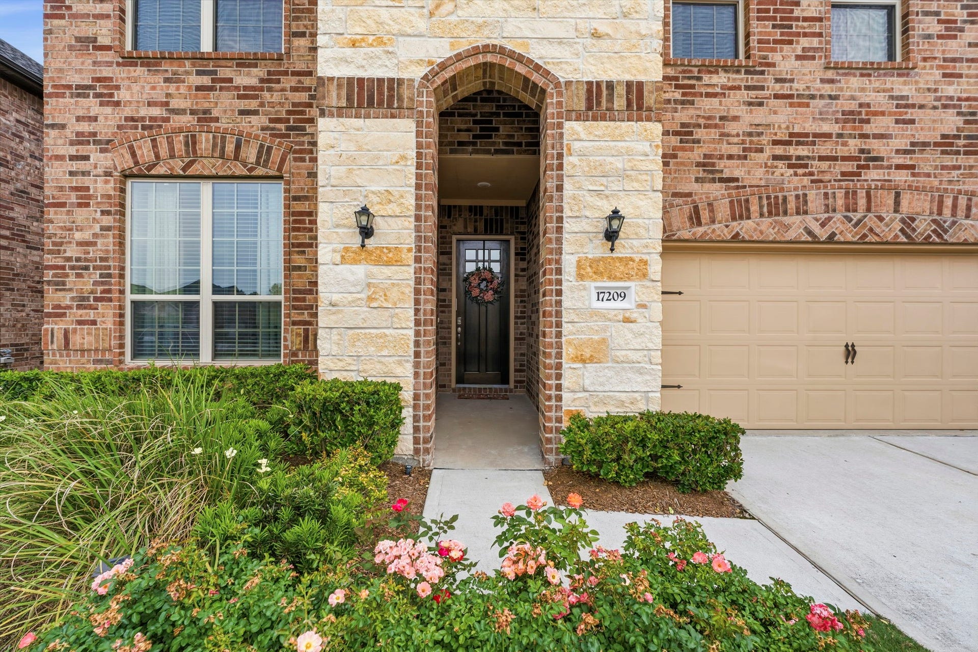 17209 Olive Blossom Court, Conroe, TX 77385 Covered front walkway leads to a beautiful wood front door, creating a warm and inviting entrance.