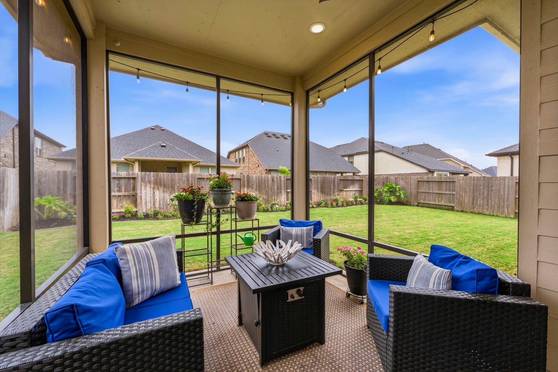 17209 Olive Blossom Court, Conroe, TX 77385 Covered and screened-in back porch with ceiling fan, offering a comfortable outdoor space to relax and enjoy views of the beautifully landscaped backyard.