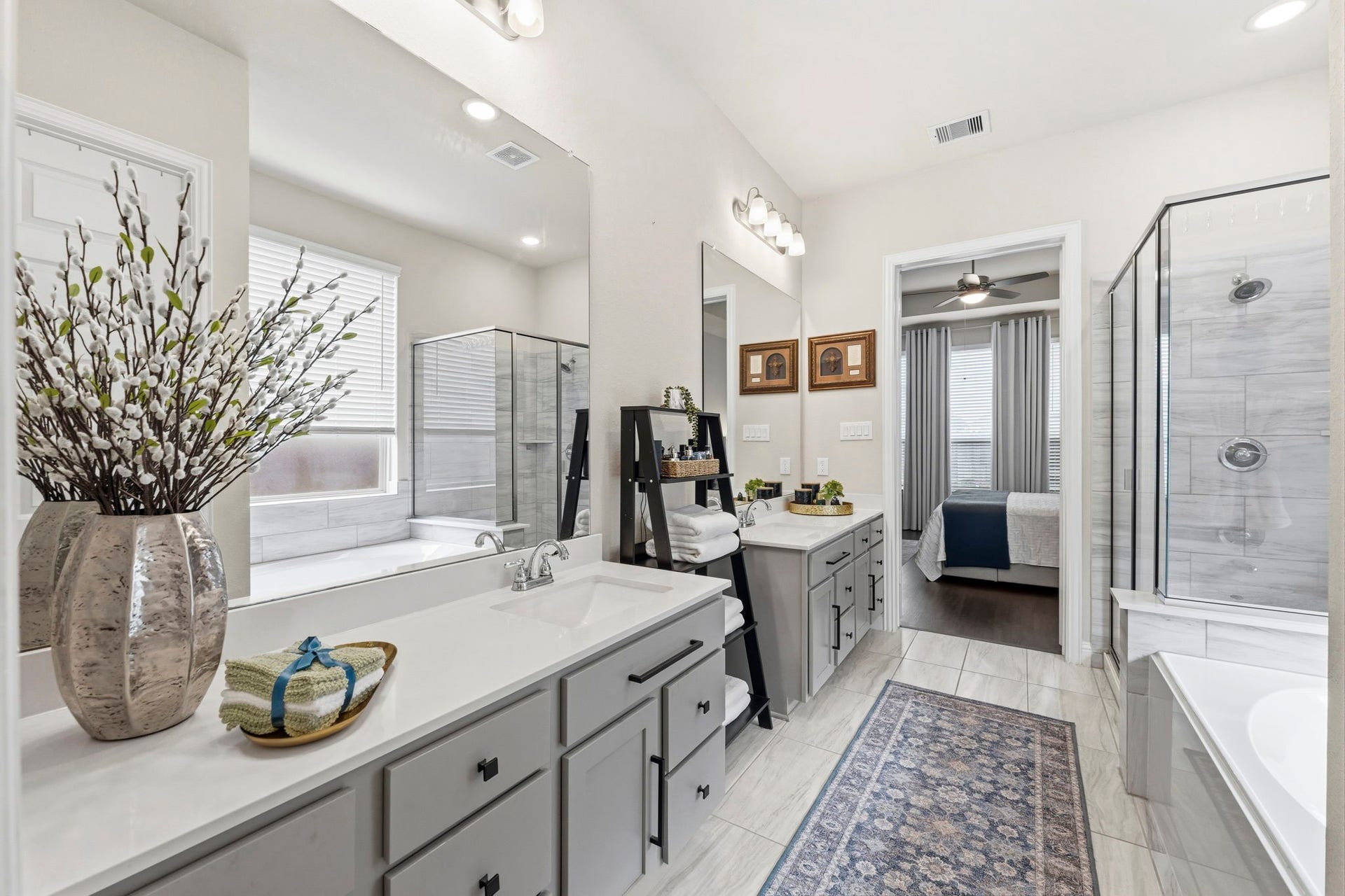 17209 Olive Blossom Court, Conroe, TX 77385 Elegant primary bath with dual vanities, quartz countertops, and gray cabinetry accented by stylish black hardware.