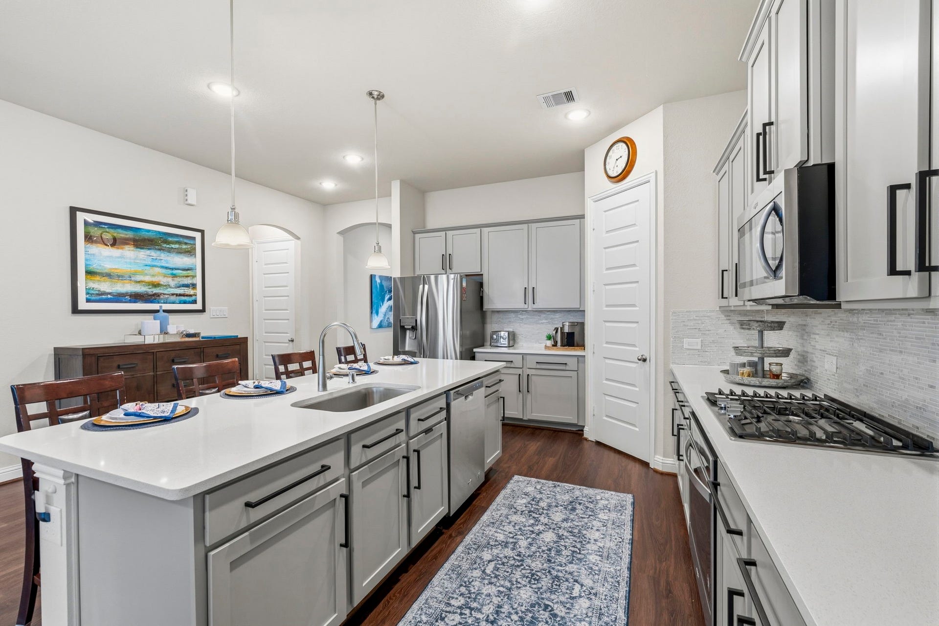 17209 Olive Blossom Court, Conroe, TX 77385 Kitchen features a spacious walk-in pantry with abundant shelving, beautiful gray cabinetry with plenty of storage, and a stylish stacked tile backsplash.