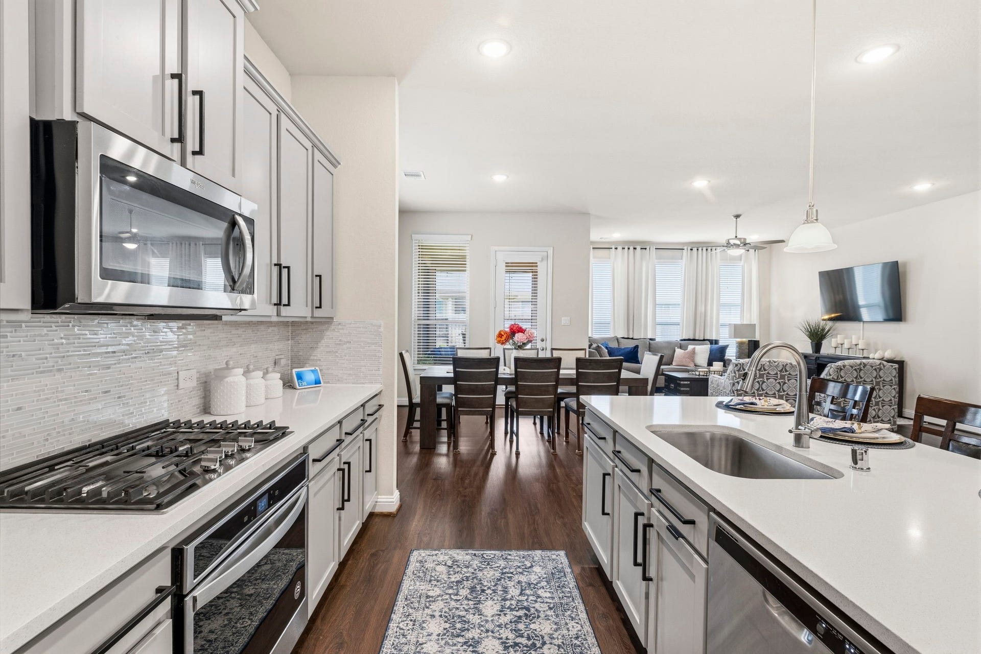 17209 Olive Blossom Court, Conroe, TX 77385 Stunning kitchen with quartz countertops, gas cooktop, stainless steel appliances, and a large island with seatingopen to the dining area and family room.
