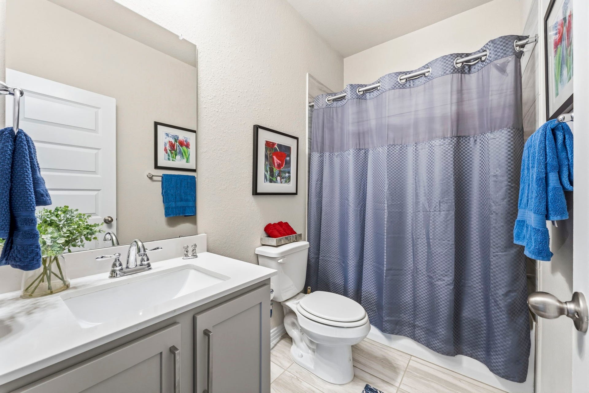 17209 Olive Blossom Court, Conroe, TX 77385 Upstairs secondary bath featuring a gray vanity, quartz countertops, and a stylish, modern design.