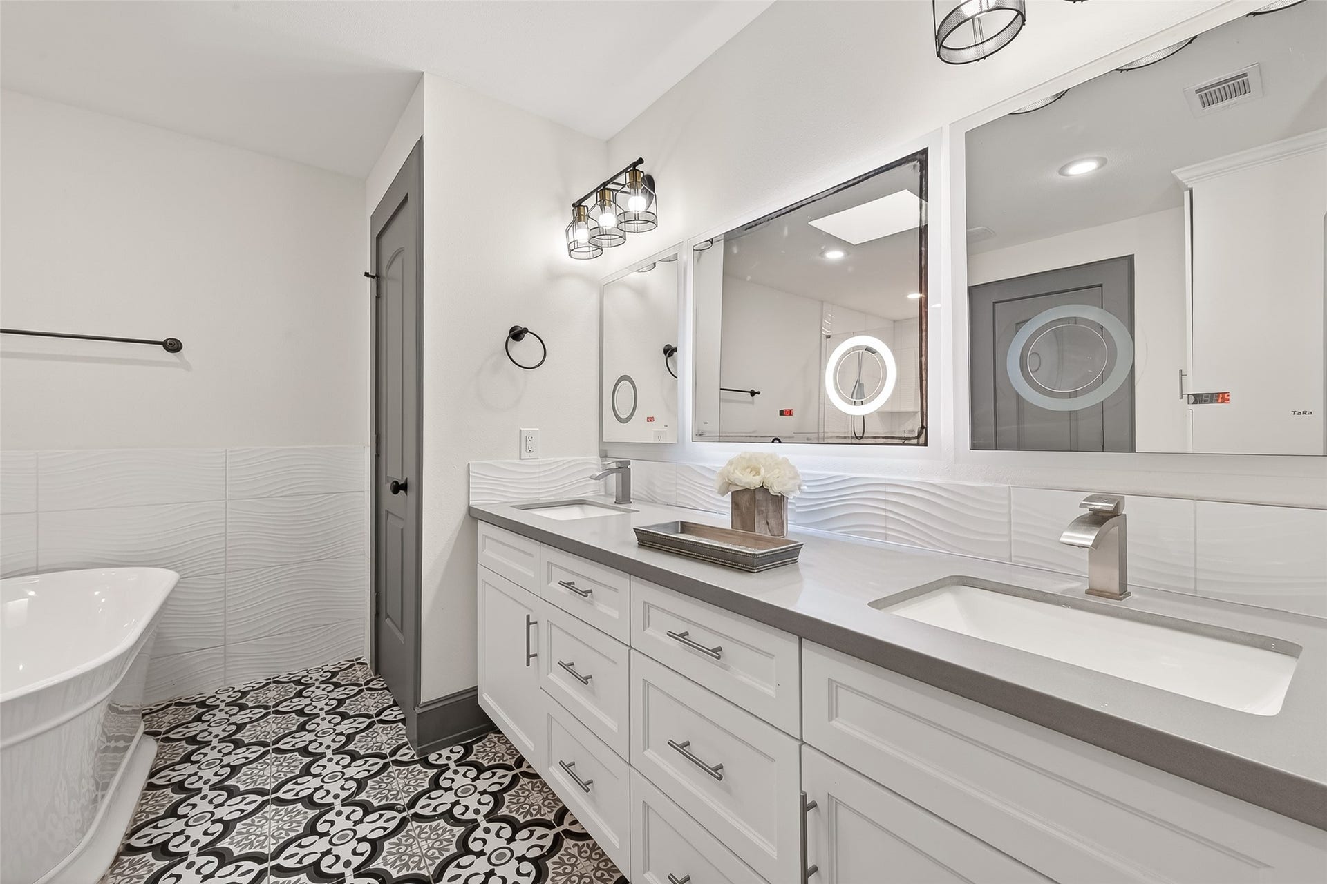 10054 Cedardale Drive, Houston, TX 77055 The dual-sink vanity offers ample storage, while patterned floor tiles add a touch of elegance.