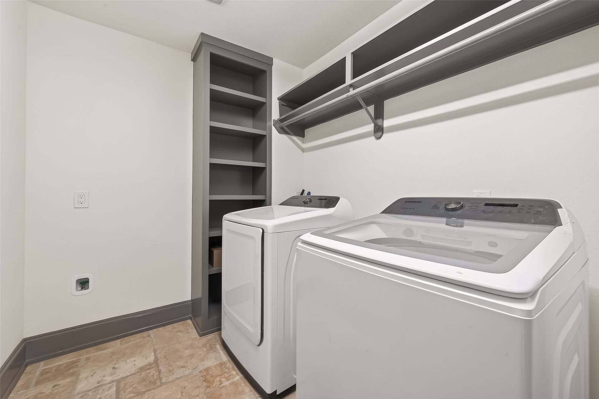 10054 Cedardale Drive, Houston, TX 77055 laundry room featuring a washer and dryer set, with built-in shelving and a hanging rod for convenience.