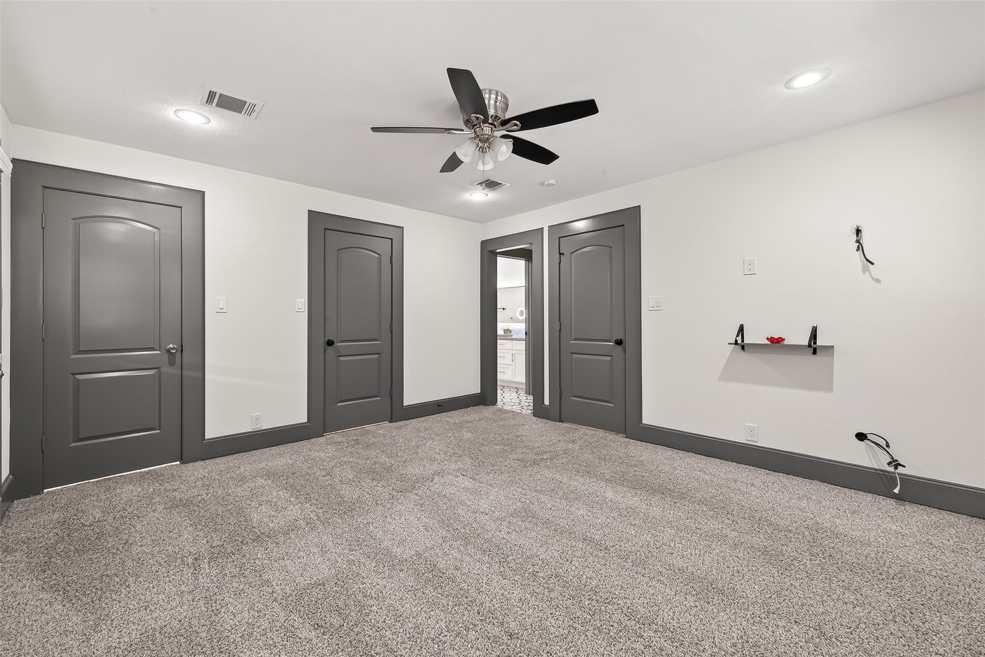 10054 Cedardale Drive, Houston, TX 77055 It includes a ceiling fan and a small wall shelf. The neutral color scheme offers a modern, clean look, perfect for a bedroom or office space.