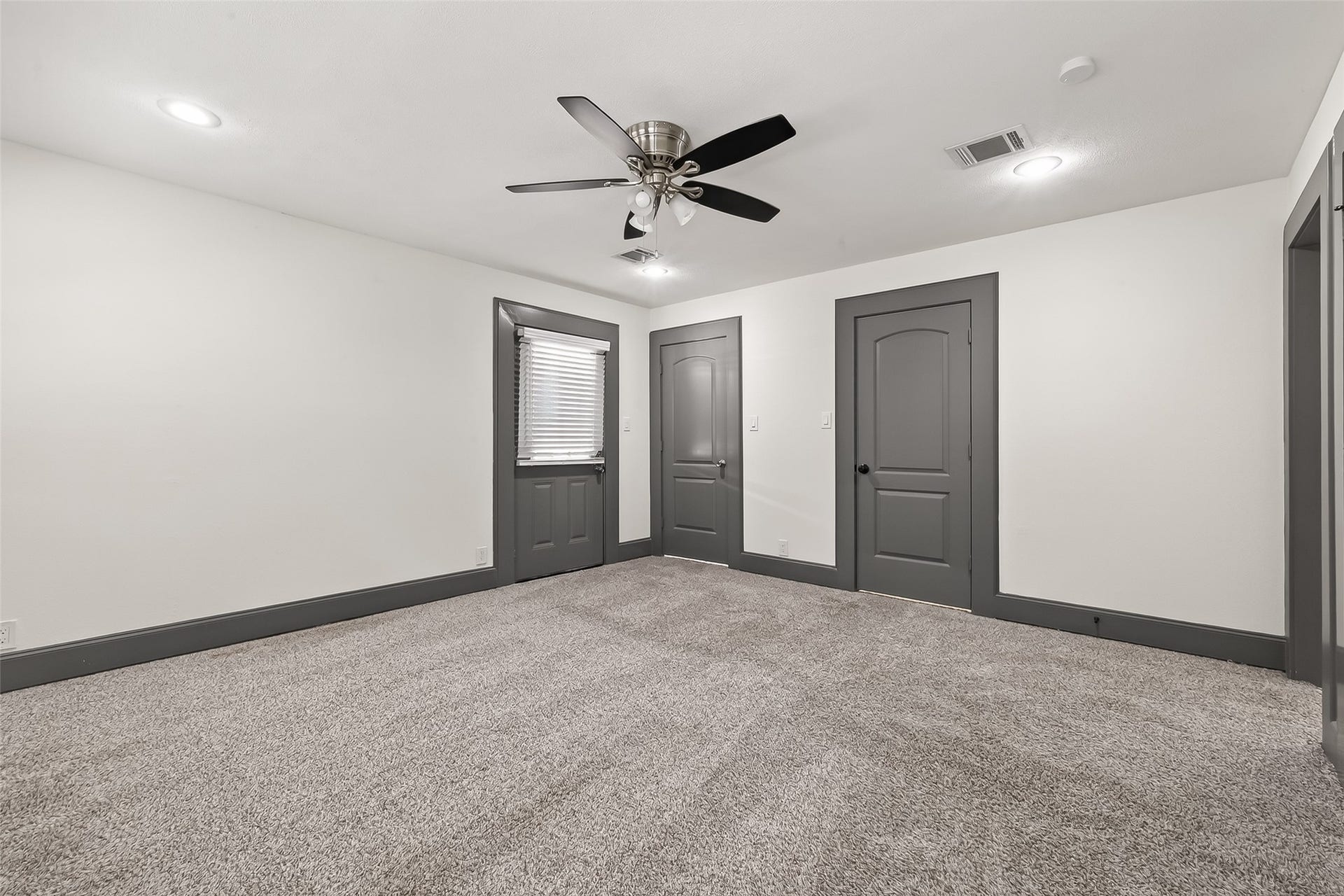 10054 Cedardale Drive, Houston, TX 77055 This room features neutral walls and carpeting, accented by dark trim and doors.