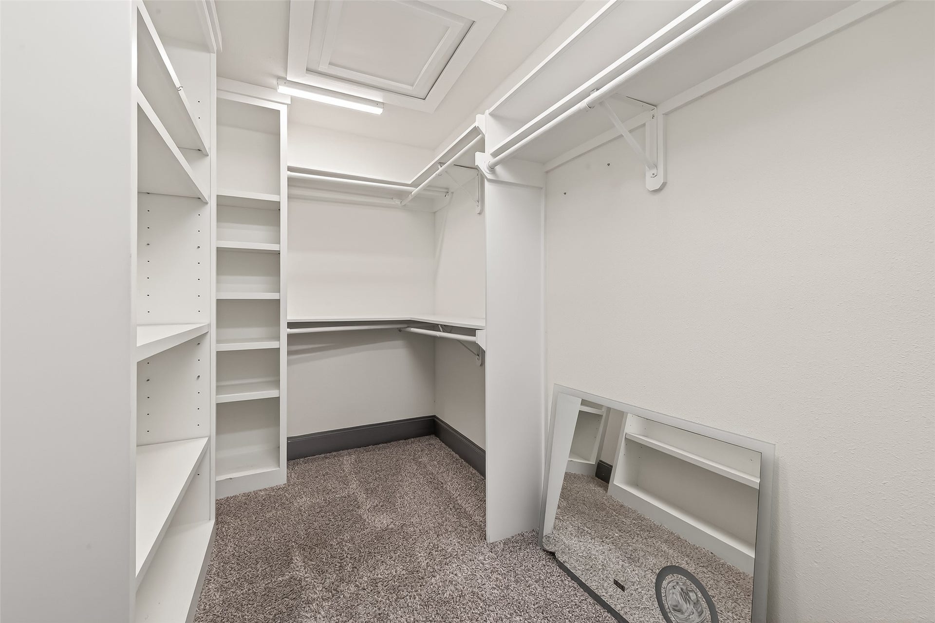 10054 Cedardale Drive, Houston, TX 77055 This is a walk-in closet with ample shelving and hanging space. It features carpeted flooring and a large mirror, perfect for organizing clothes and accessories.