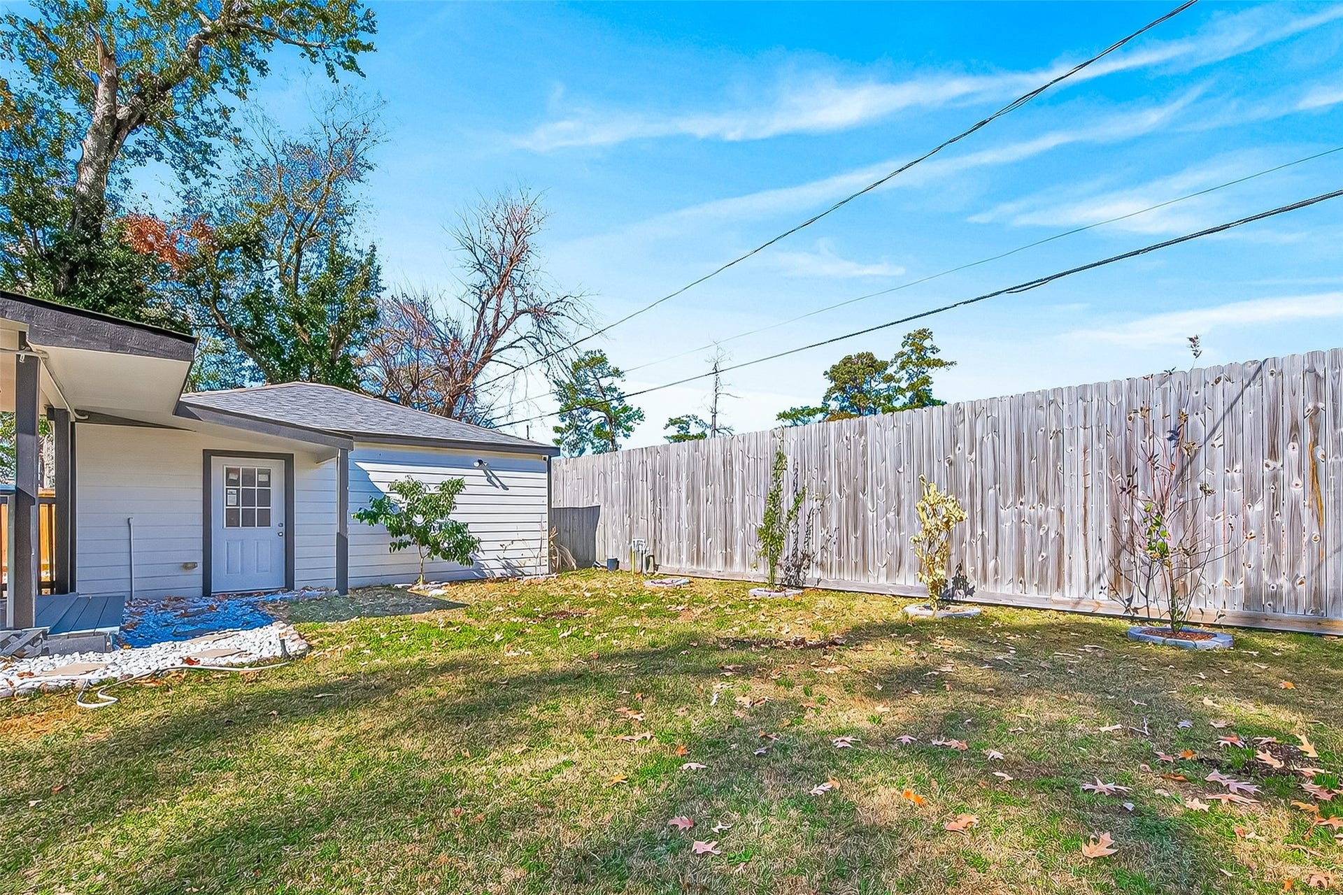 10054 Cedardale Drive, Houston, TX 77055 A backyard with a grassy lawn and a wooden fence.