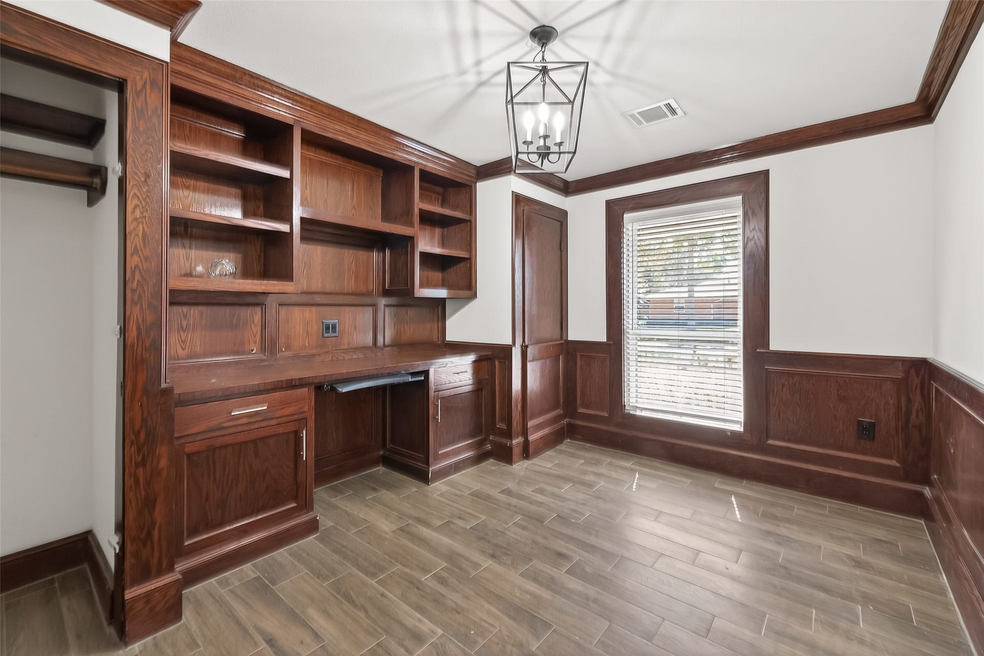 10054 Cedardale Drive, Houston, TX 77055 This room has elegant dark wood paneling and built-in shelving with a workspace.