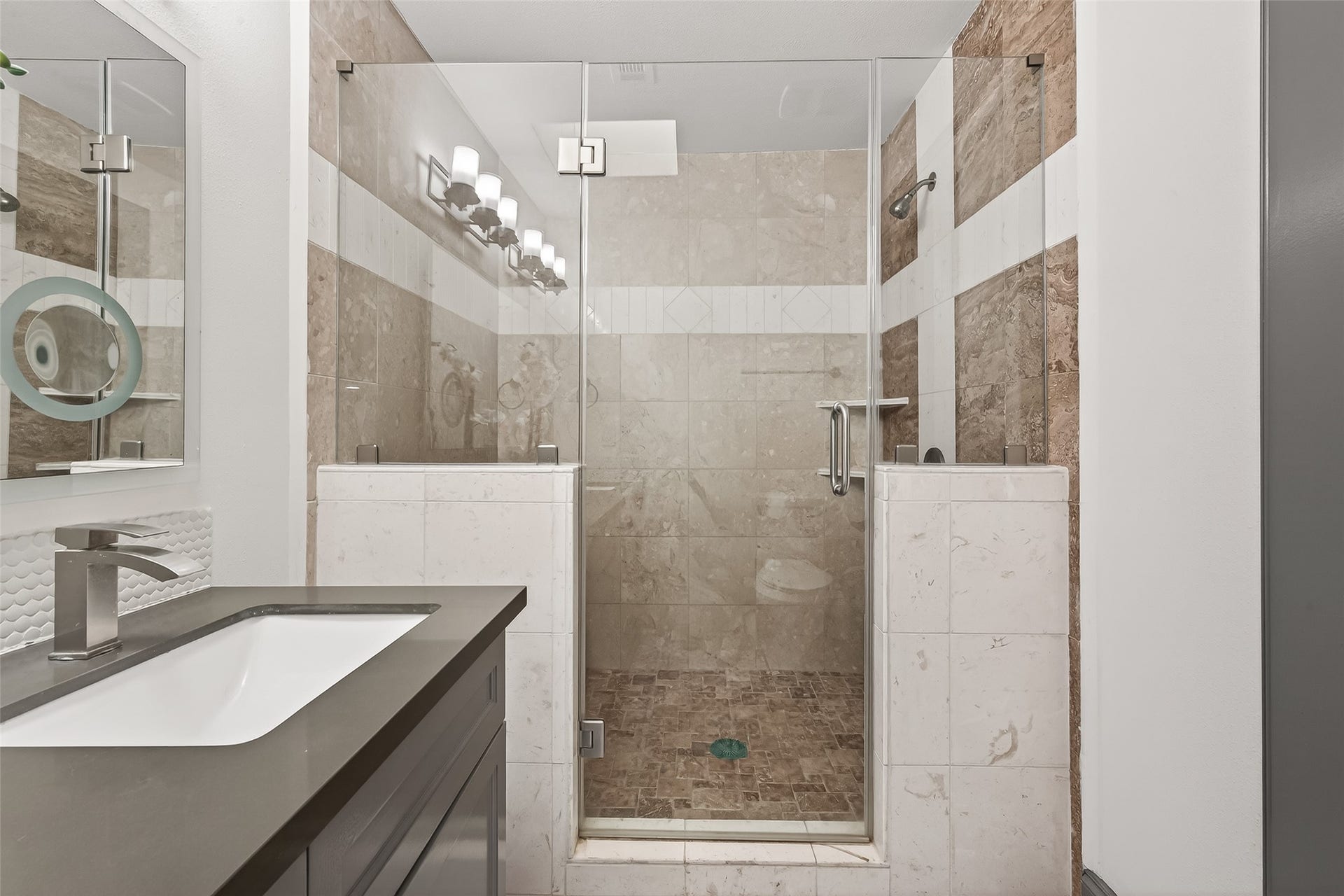 10054 Cedardale Drive, Houston, TX 77055 The vanity includes a sleek sink with contemporary fixtures, complemented by a well-lit mirror.