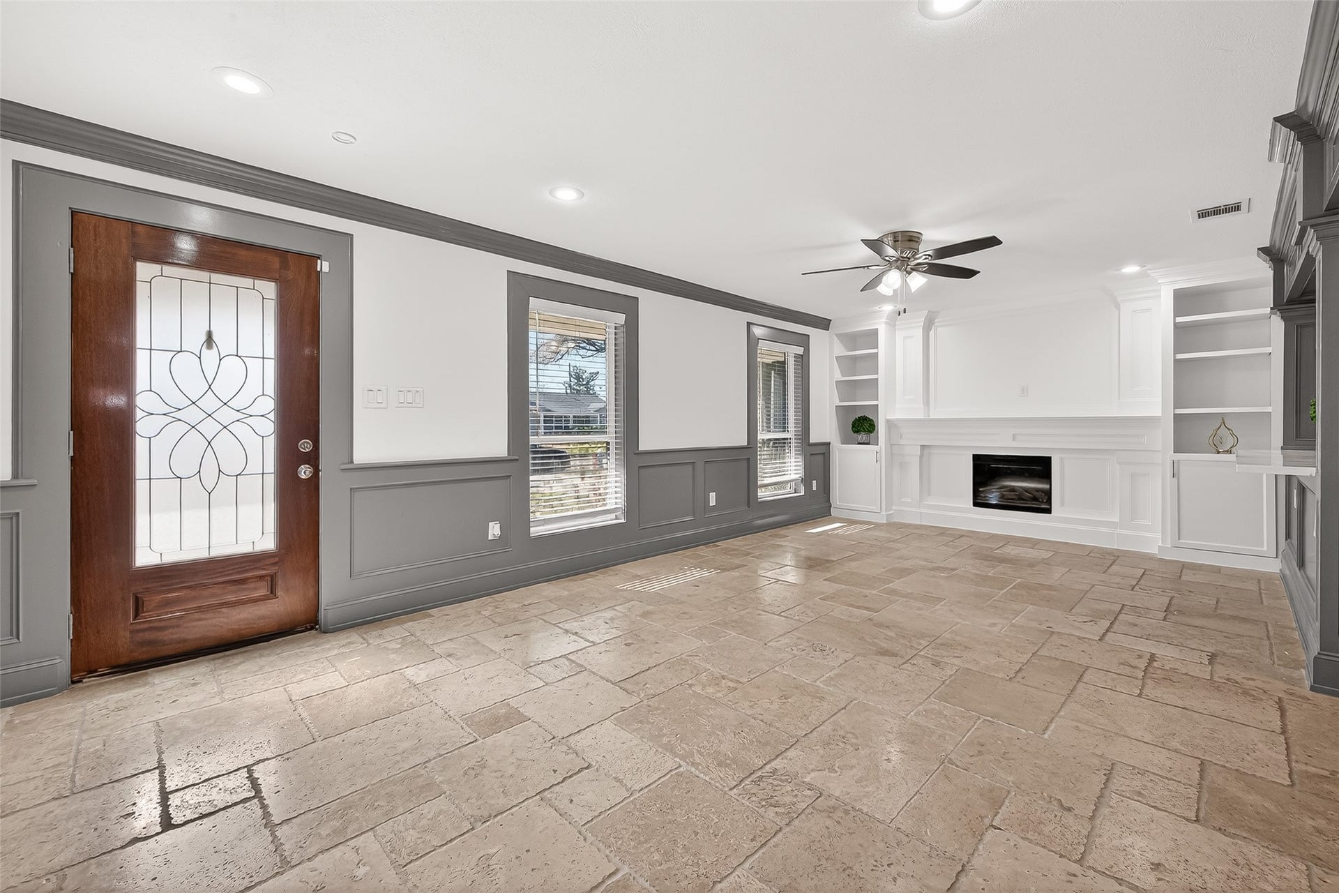 10054 Cedardale Drive, Houston, TX 77055 Living room with tiled flooring, a stylish wooden door, and large windows.