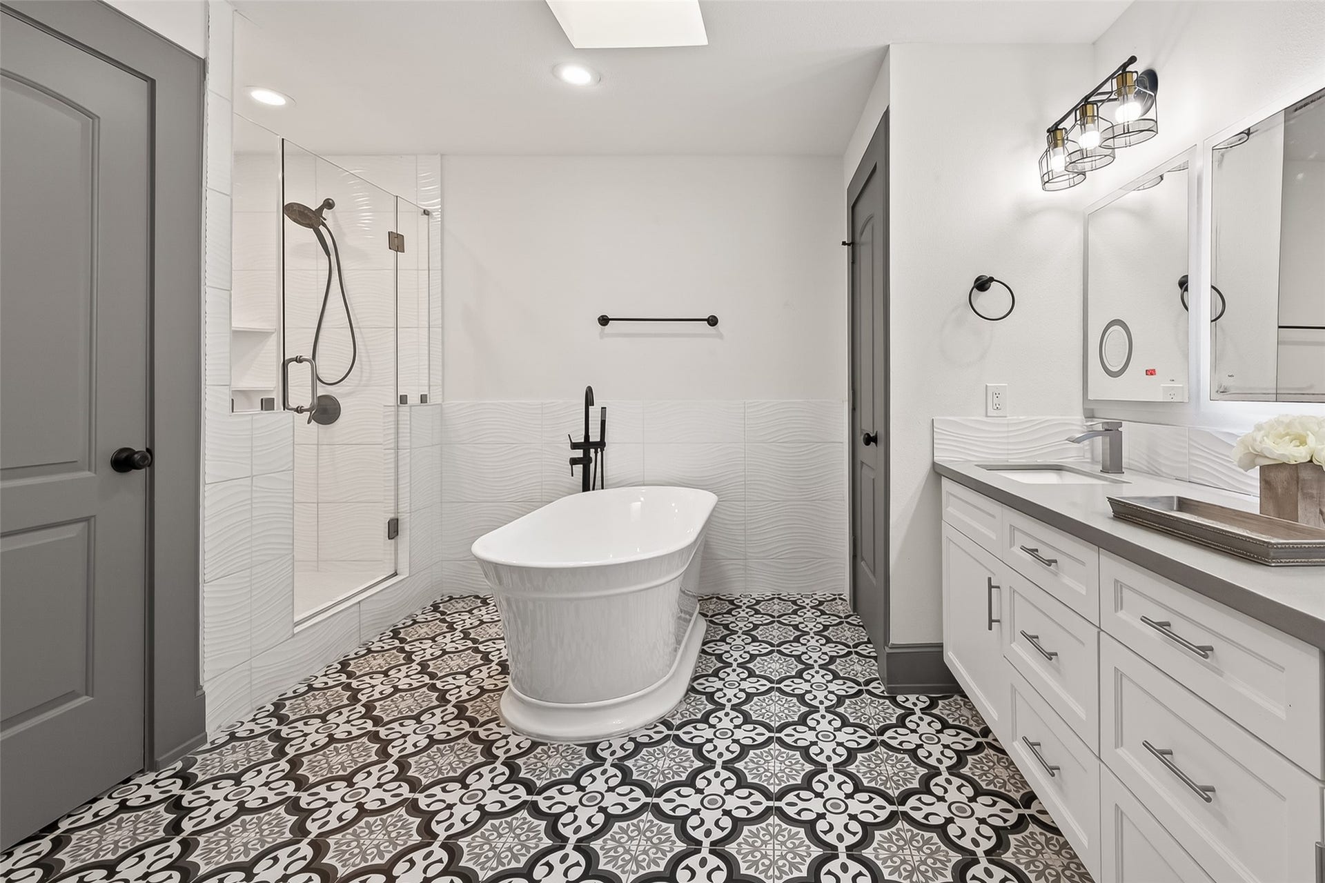 10054 Cedardale Drive, Houston, TX 77055 This bathroom features a sleek, modern design with a freestanding bathtub and a spacious glass-enclosed shower.