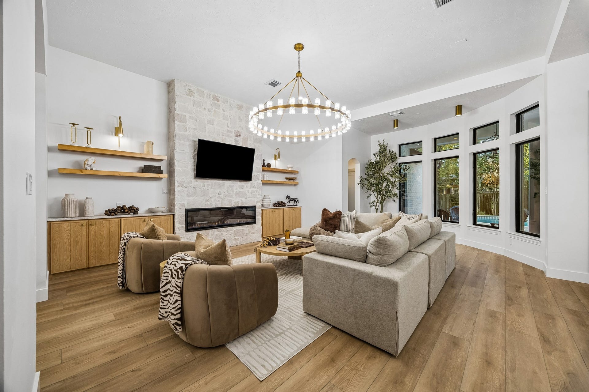 34 N Lansdowne Circle, The Woodlands, TX 77382 The living room features a stunning chandelier, custom cabinetry and shelving