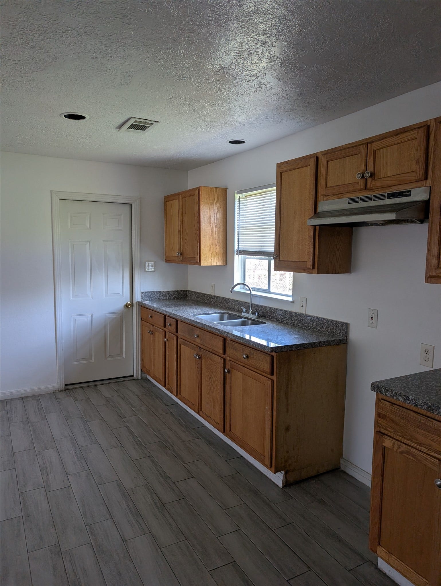 109 E Parker Road, Houston, TX 77076 Kitchen has granite counter tops, door leads to attached 1 car garage