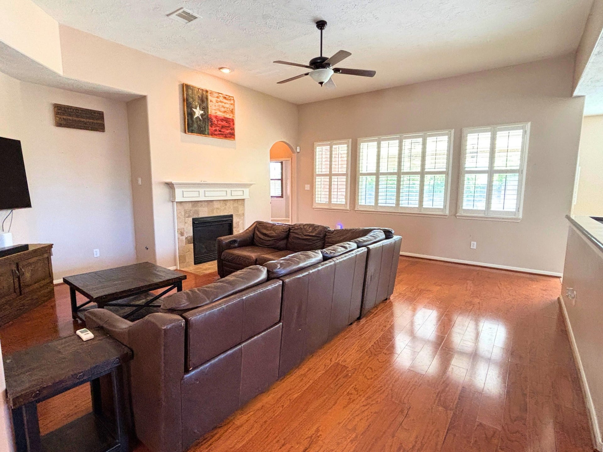 2718 Legends Ranch Drive, Spring, TX 77386 Spacious living room with hardwood floors, a gaslog fireplace, and abundant natural light.