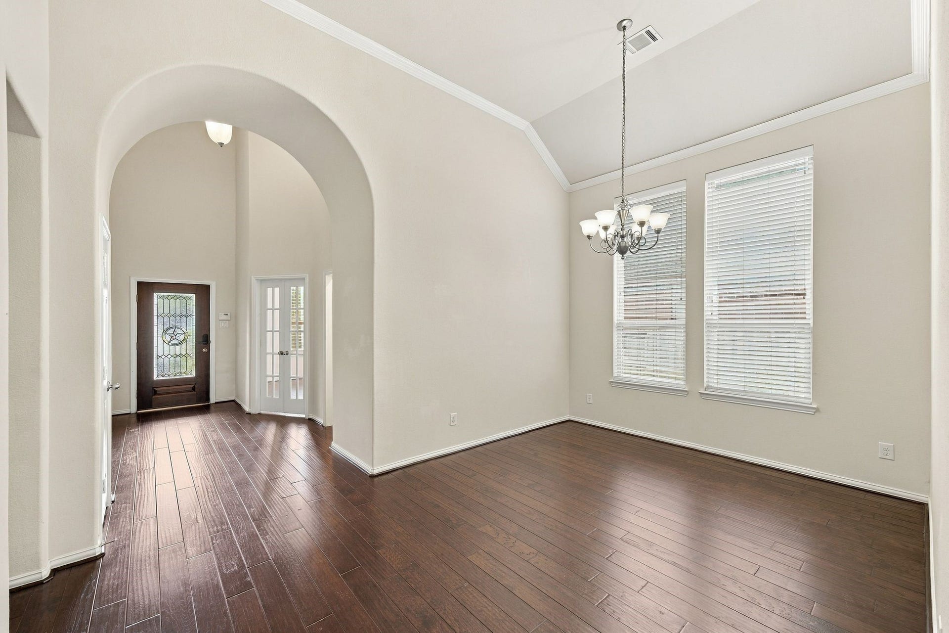 8319 Floating Heart Court, Conroe, TX 77385 Formal dining room positioned between the entry and living room, with elegant arches and rich hardwood floors.