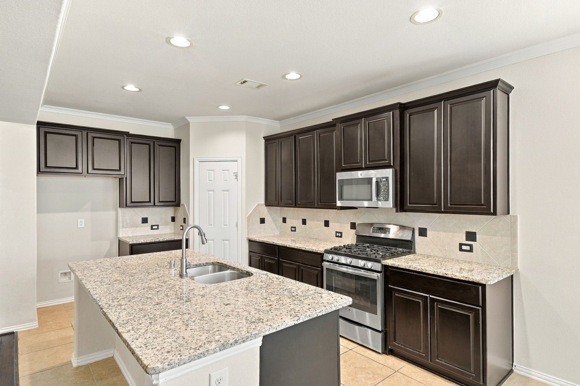 8319 Floating Heart Court, Conroe, TX 77385 Well-appointed kitchen featuring granite countertops, abundant cabinetry & gas cooking.