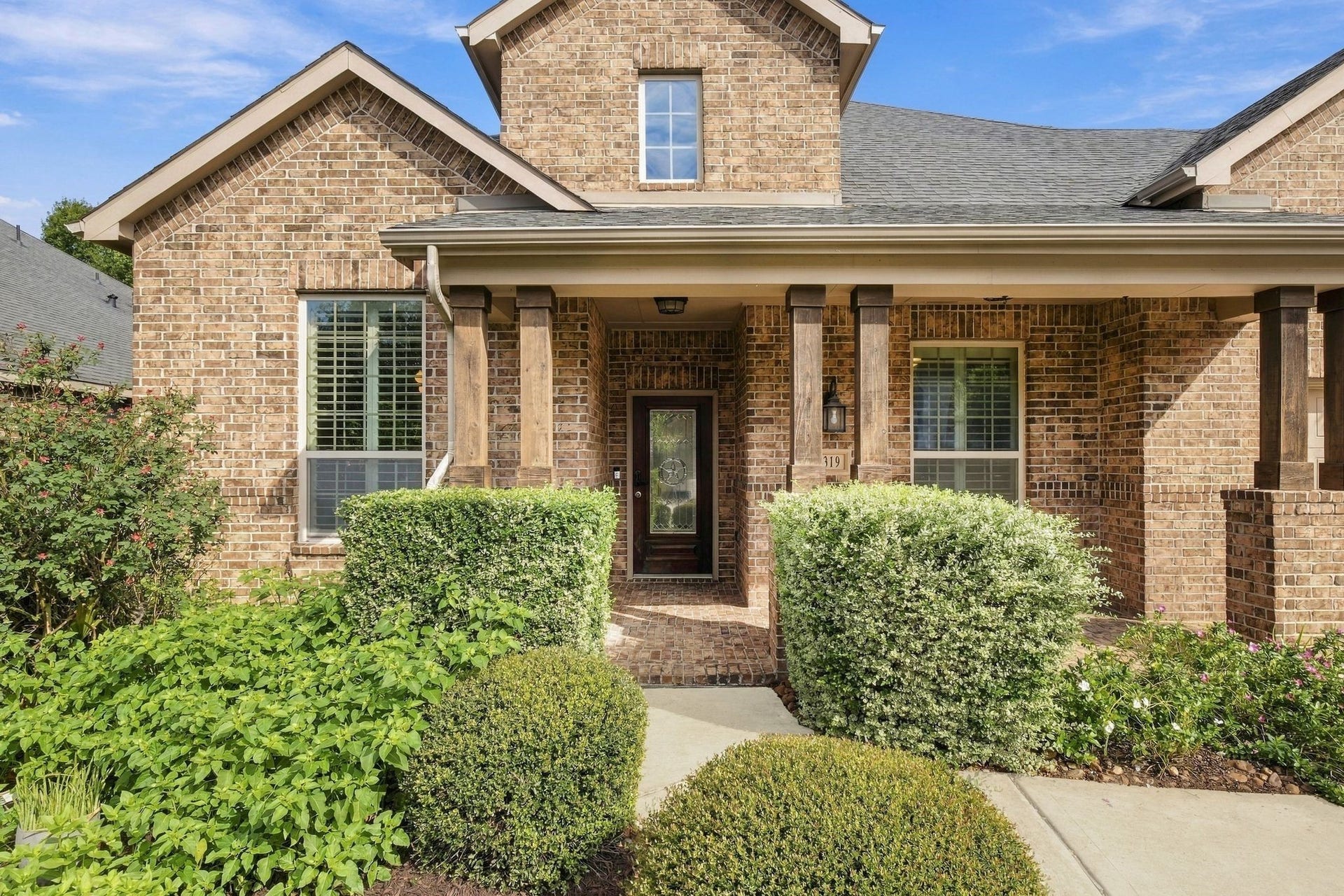 8319 Floating Heart Court, Conroe, TX 77385 Stone-and-brick architecture, mature landscaping & a welcoming covered entry.
