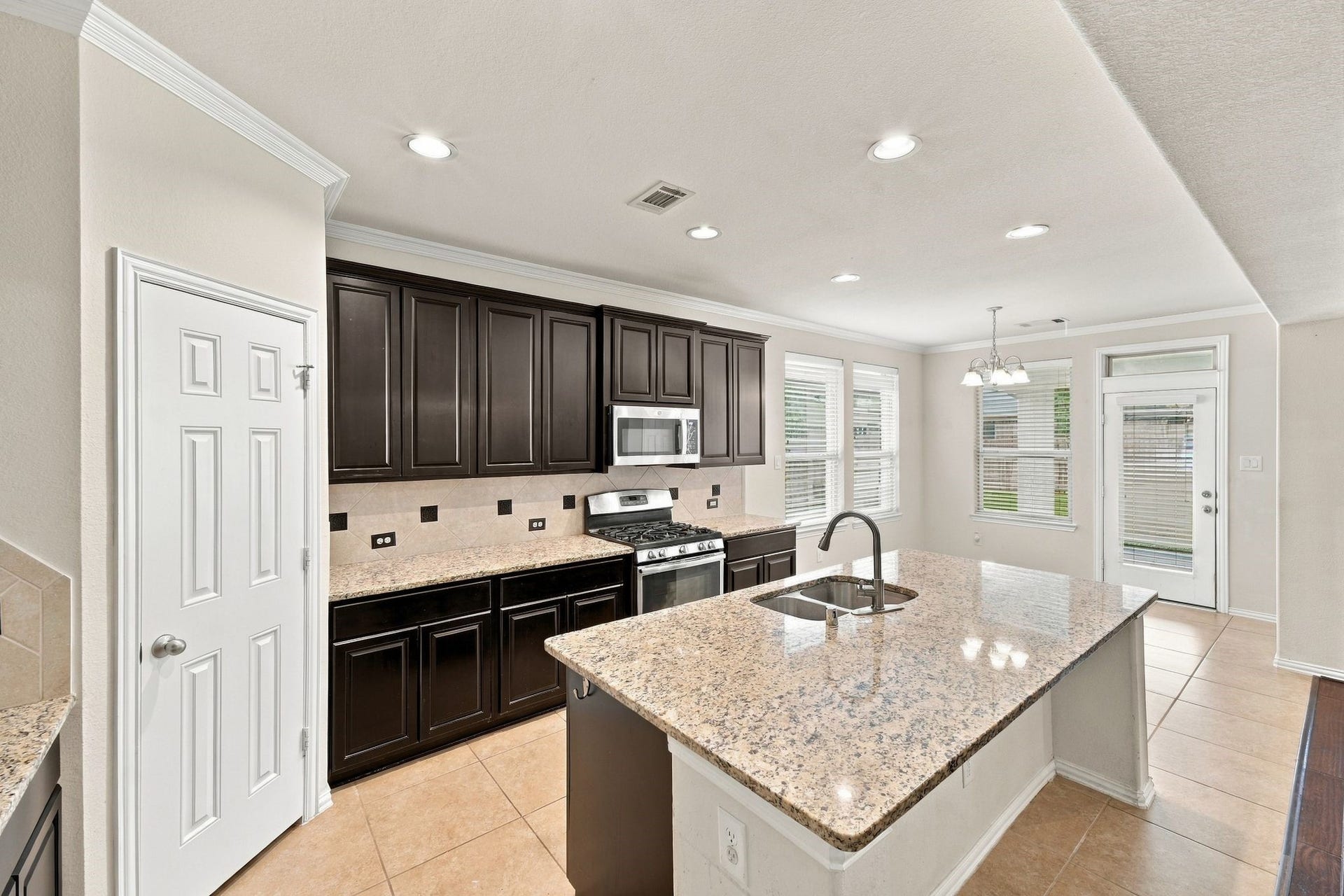 8319 Floating Heart Court, Conroe, TX 77385 Bright, open kitchen with plentiful storage, recessed lighting & views toward the breakfast nook.