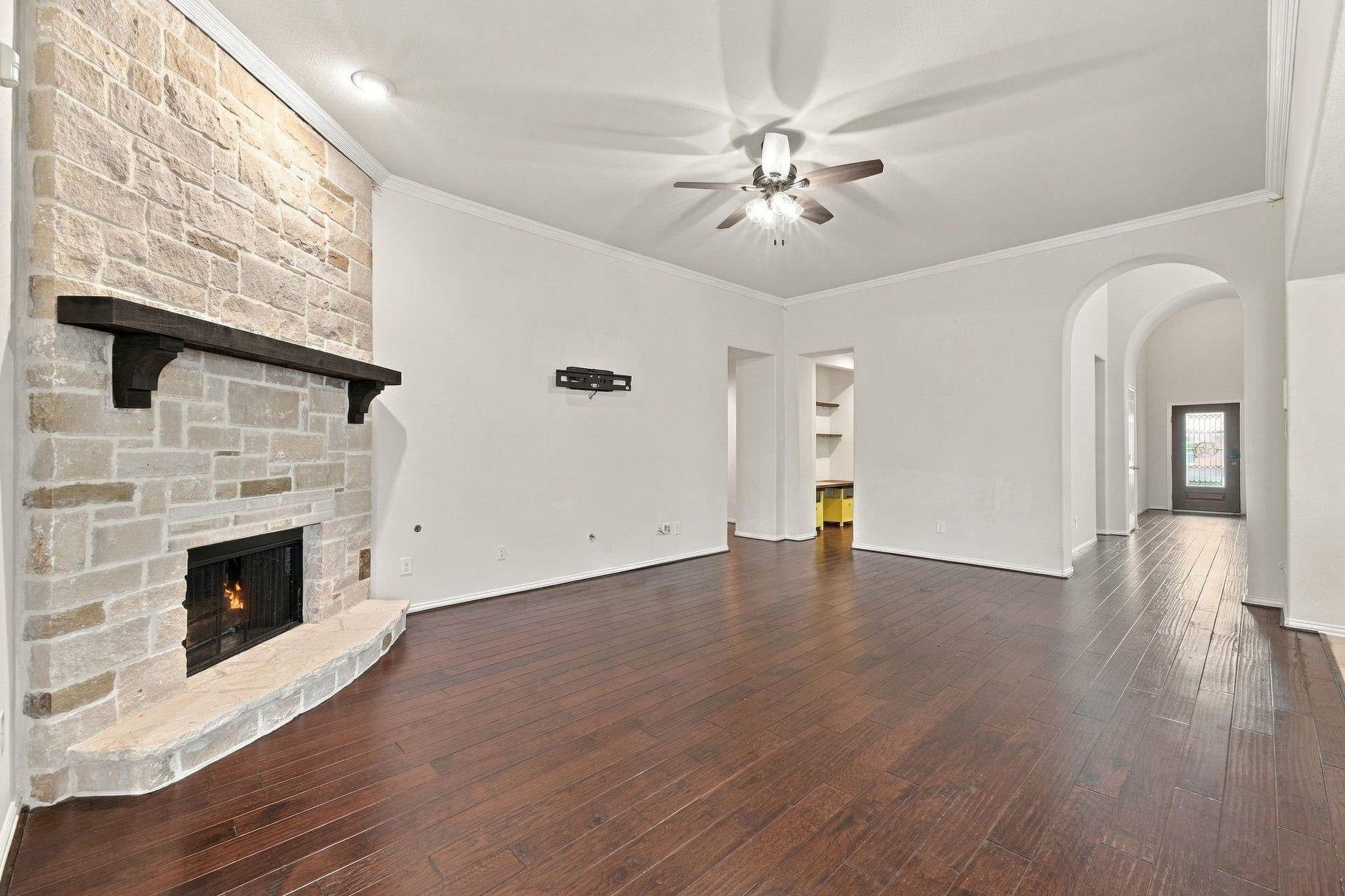 8319 Floating Heart Court, Conroe, TX 77385 Expansive living room anchored by a dramatic stone fireplace and soaring ceilings.