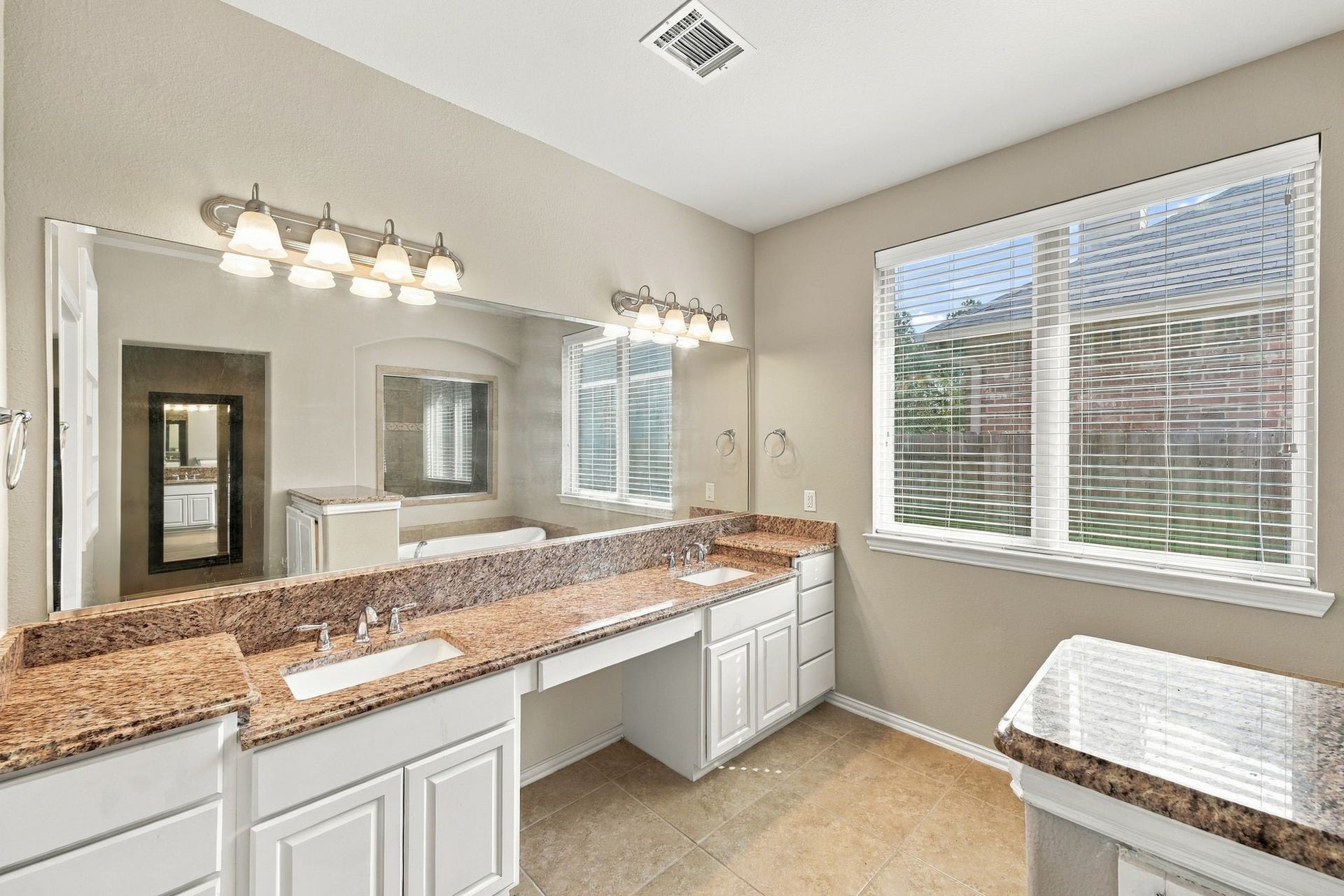 8319 Floating Heart Court, Conroe, TX 77385 Spa-inspired primary bath offering dual vanities, a soaking tub & expansive windows.