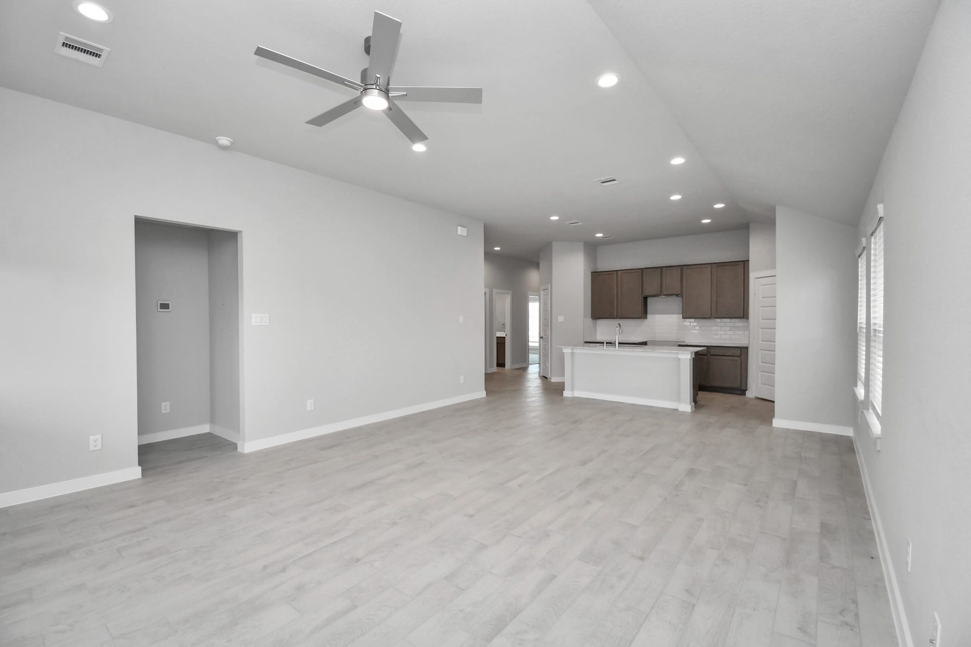 11027 Gardenia Creek Drive, Houston, TX 77044 Family room flooded with natural light through the expansive windows. The premium tile flooring adds a touch of luxury to the space, creating the perfect setting for relaxing moments and cherished gatherings with loved ones. Sample photo of completed home with similar floor plan. Actual colors and selections may vary.