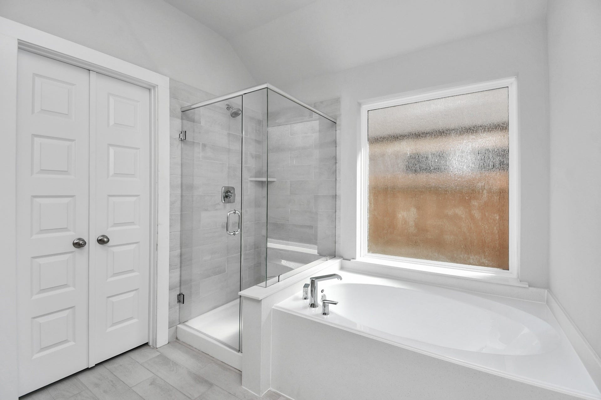 11027 Gardenia Creek Drive, Houston, TX 77044 Indulge in a spa-like retreat within the confines of this primary bathroom. Delight in a spacious walk-in shower enveloped in stylish tile surround and unwind in a separate garden tub adorned with custom detailing. Sample photo of completed home with similar floor plan. Actual colors and selections may vary.