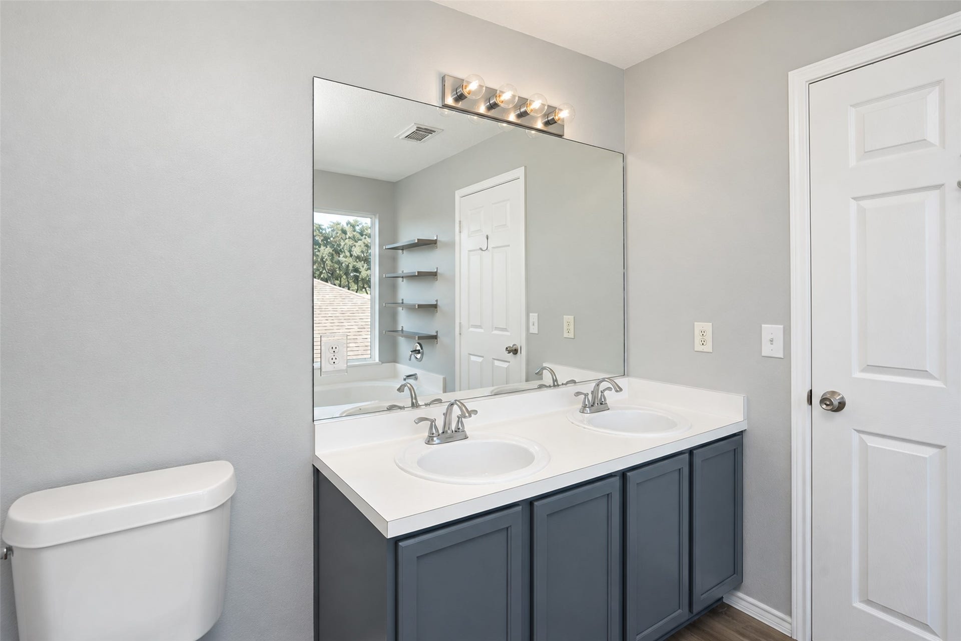 21203 Somerset Park Lane, Katy, TX 77450 Elegant primary bathroom featuring a double vanity with sleek faucets, a large mirror, and modern lighting.