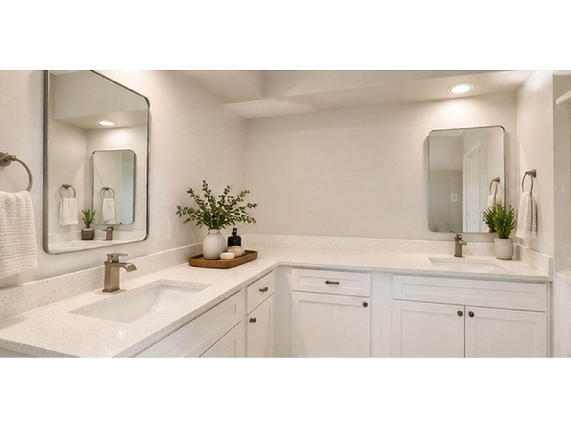 Elegant bathroom featuring dual sinks with sleek countertops, modern fixtures, and ample cabinetry for storage, complemented by soft lighting and tasteful decor.