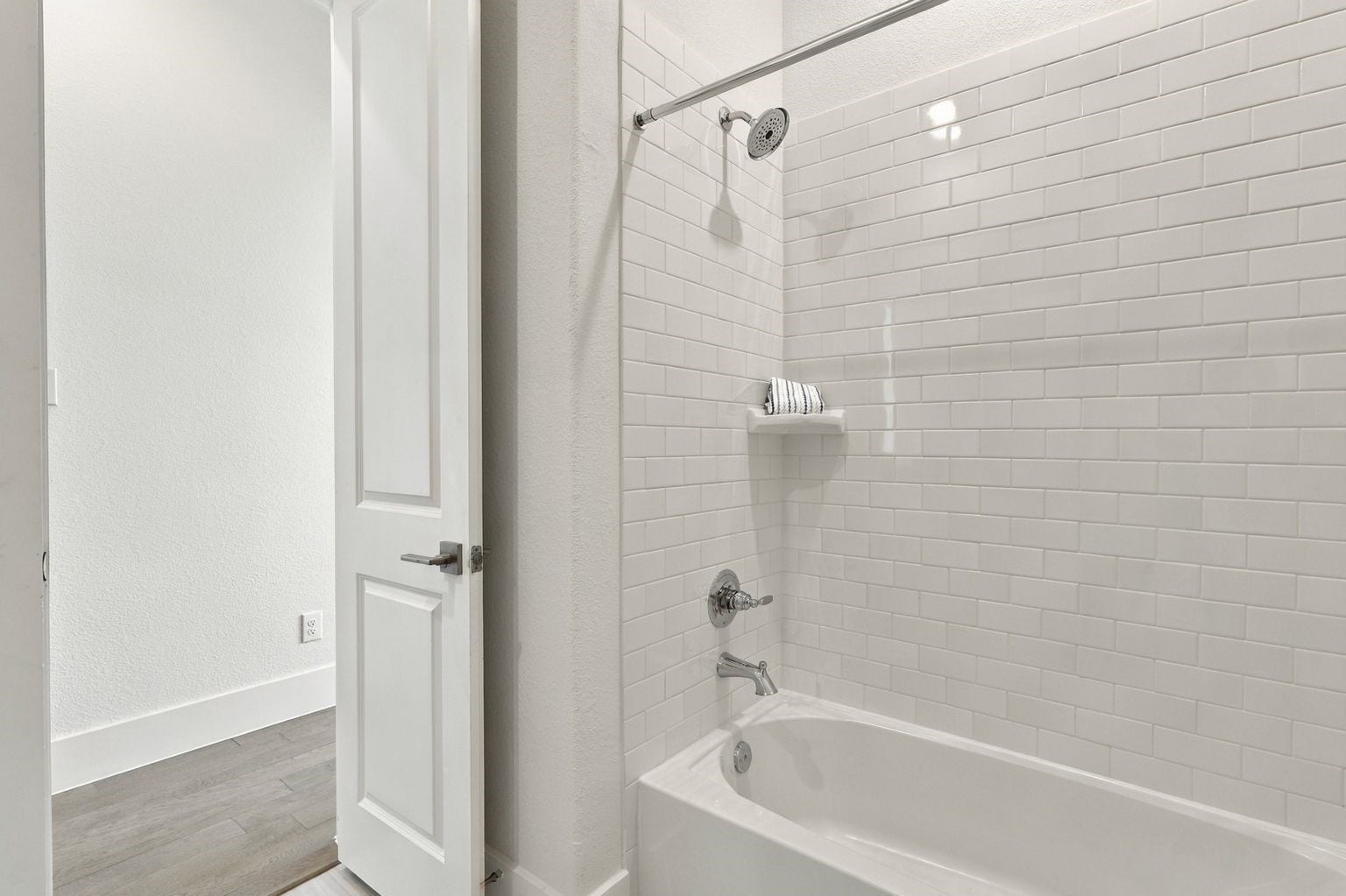This bathroom has tub and shower combination with stunning chic subway grass tile surroundings!