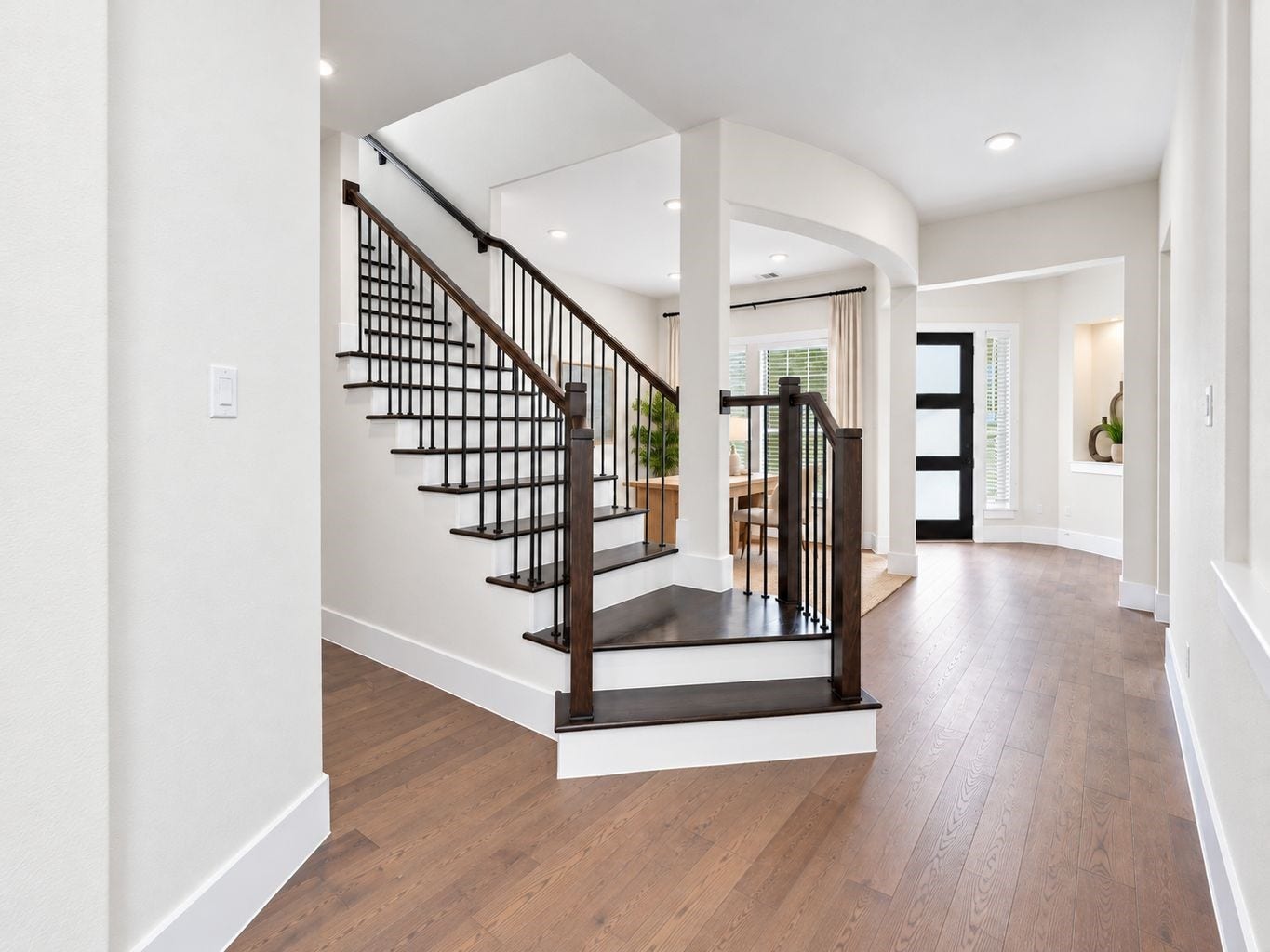 SHOWSTOPPING STAIRCASE & WELCOMING FOYER! Make a memorable first impression with this ELEGANT entry featuring a striking staircase with dark railings, high ceilings, and gorgeous engineered wood flooring throughout the main living areas! The open layout creates a seamless connection between the foyer and adjoining living spaces! **Photo is Virtually Staged**