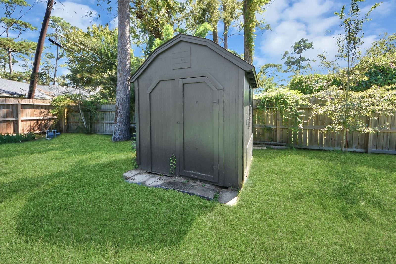 3013 Woodland Drive, Dickinson, TX 77539 Storage shed with fresh paint.